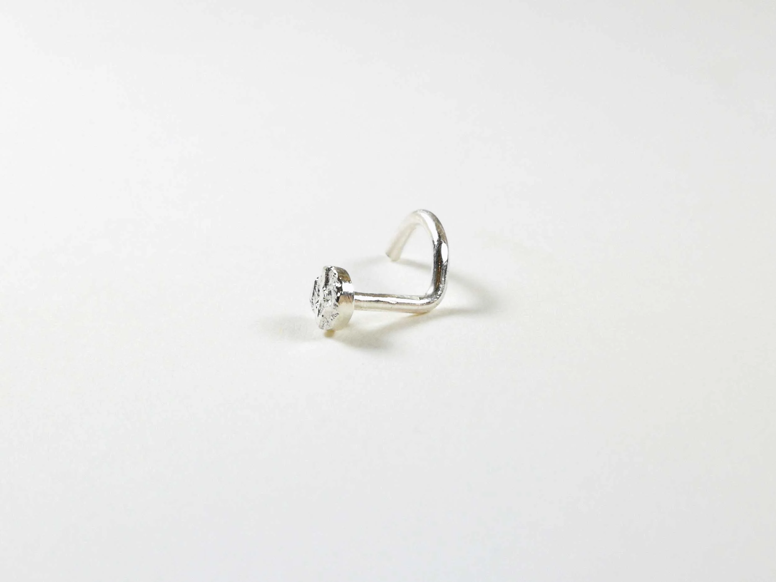 Handmade silver nose stud on white background