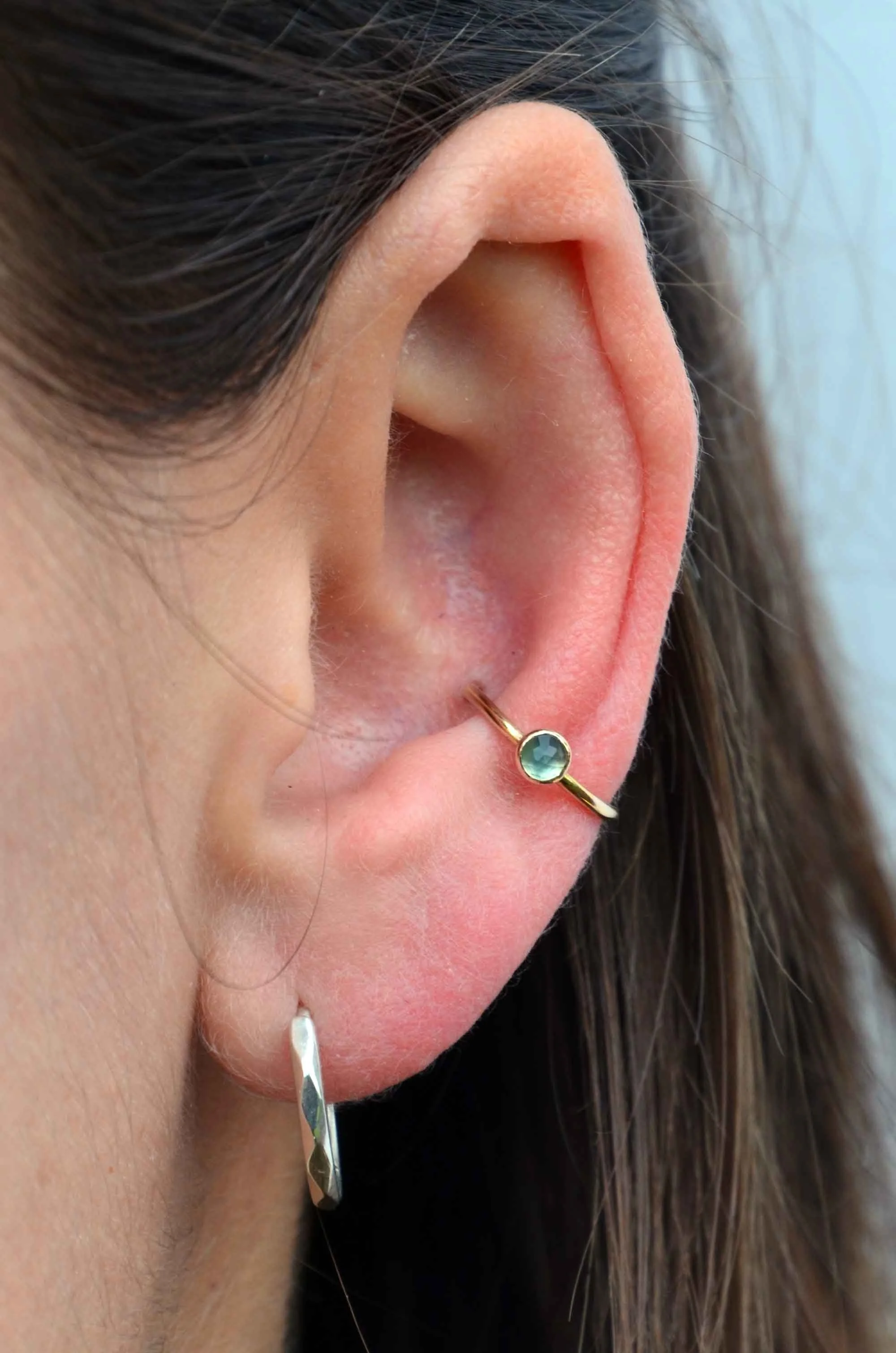 solid gold and blue topaz conch ring on model