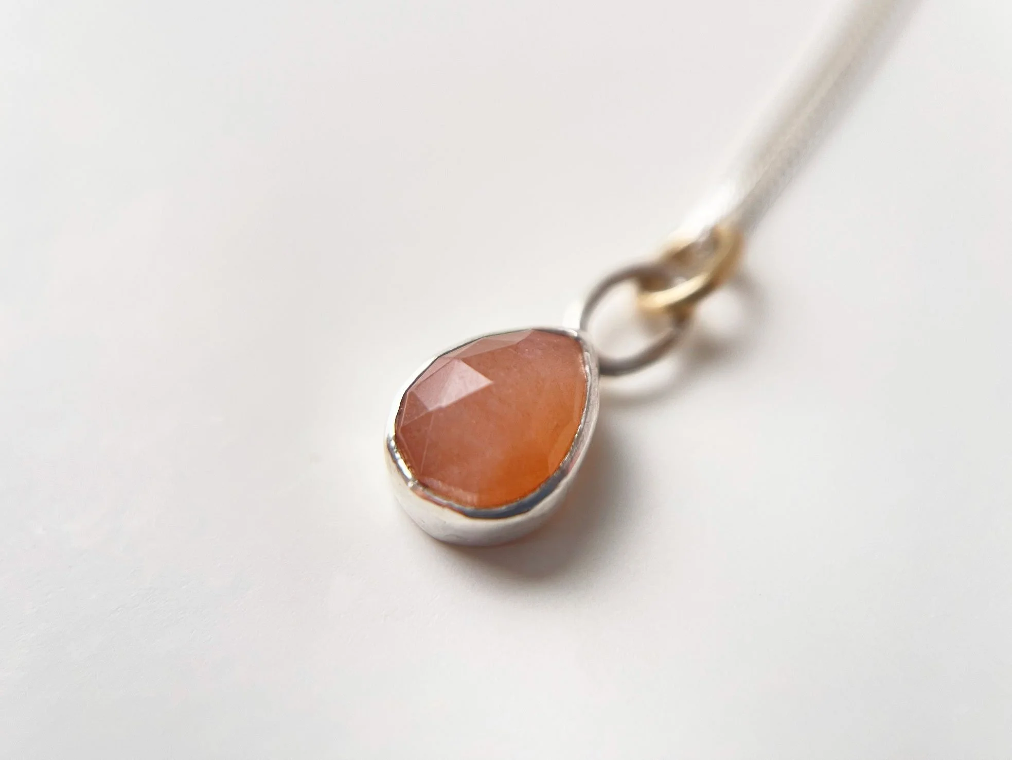 peach moonstone and silver pendant on chain close up