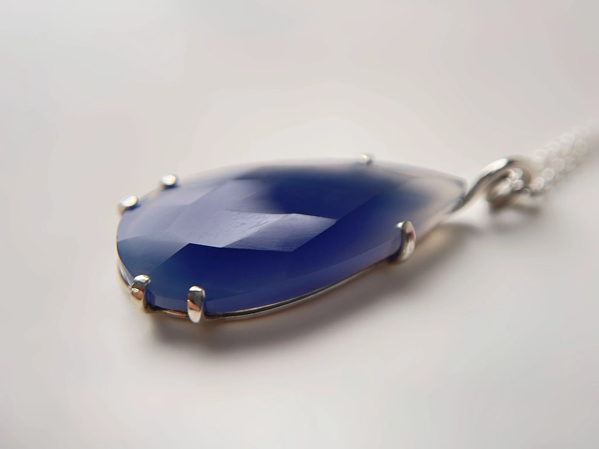 large rose cut teardrop blue chalcedony gemstone in silver claw setting
