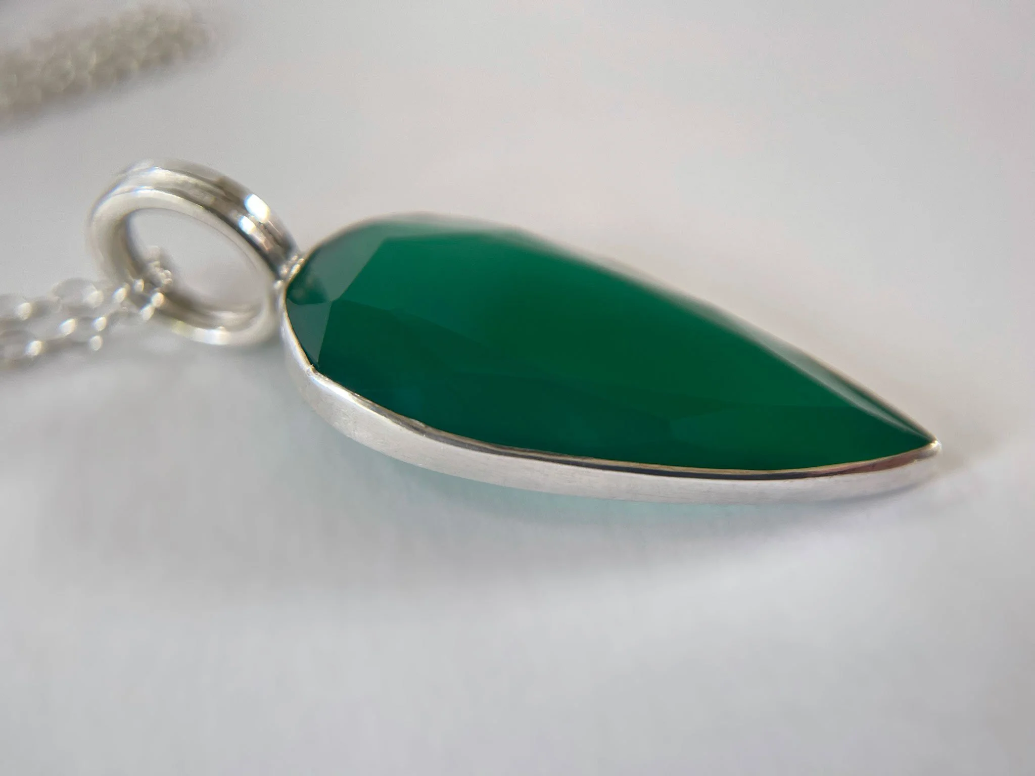 big green gemstone and silver pendant close up