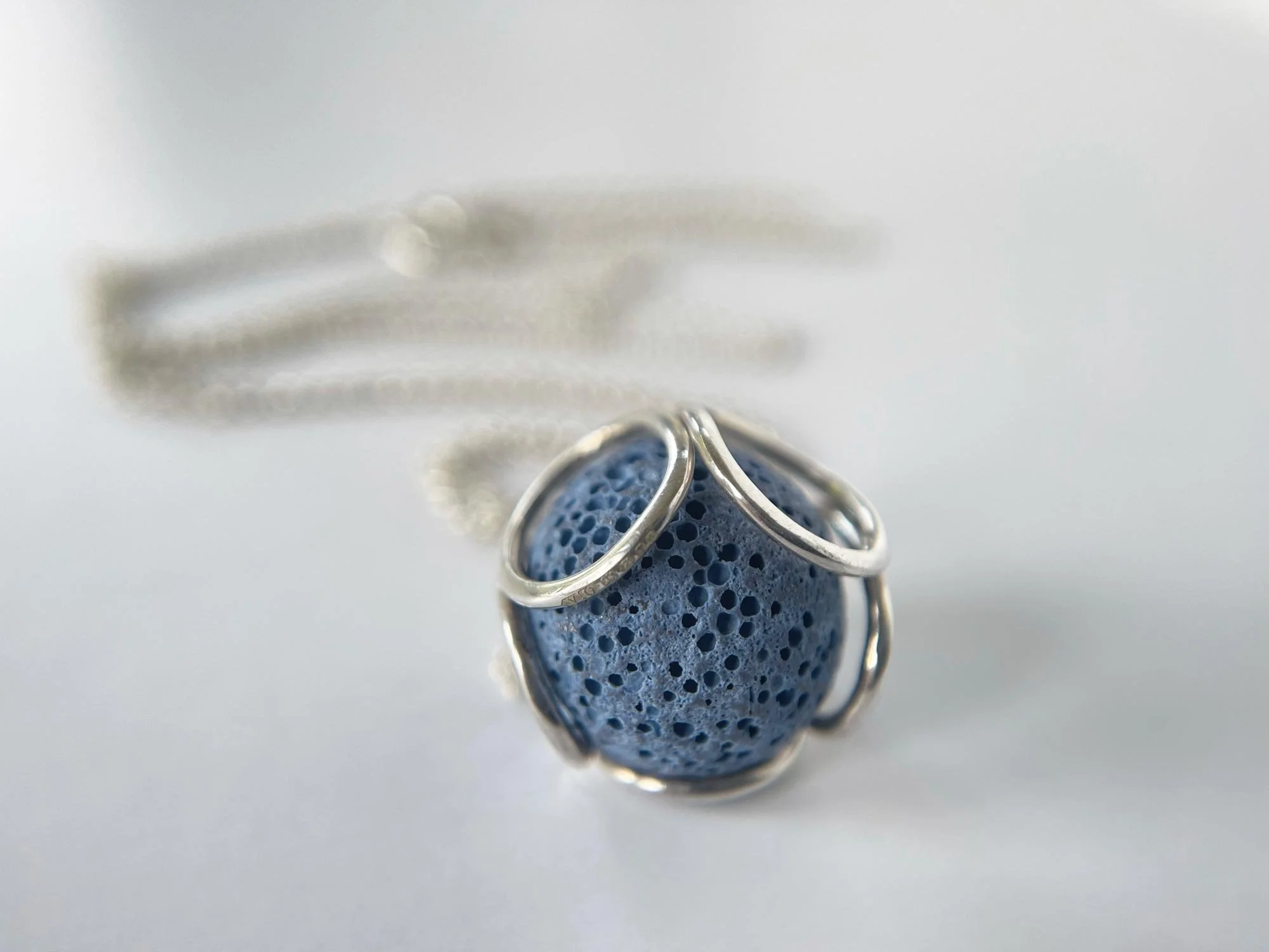 blue lava bead and silver necklace white background