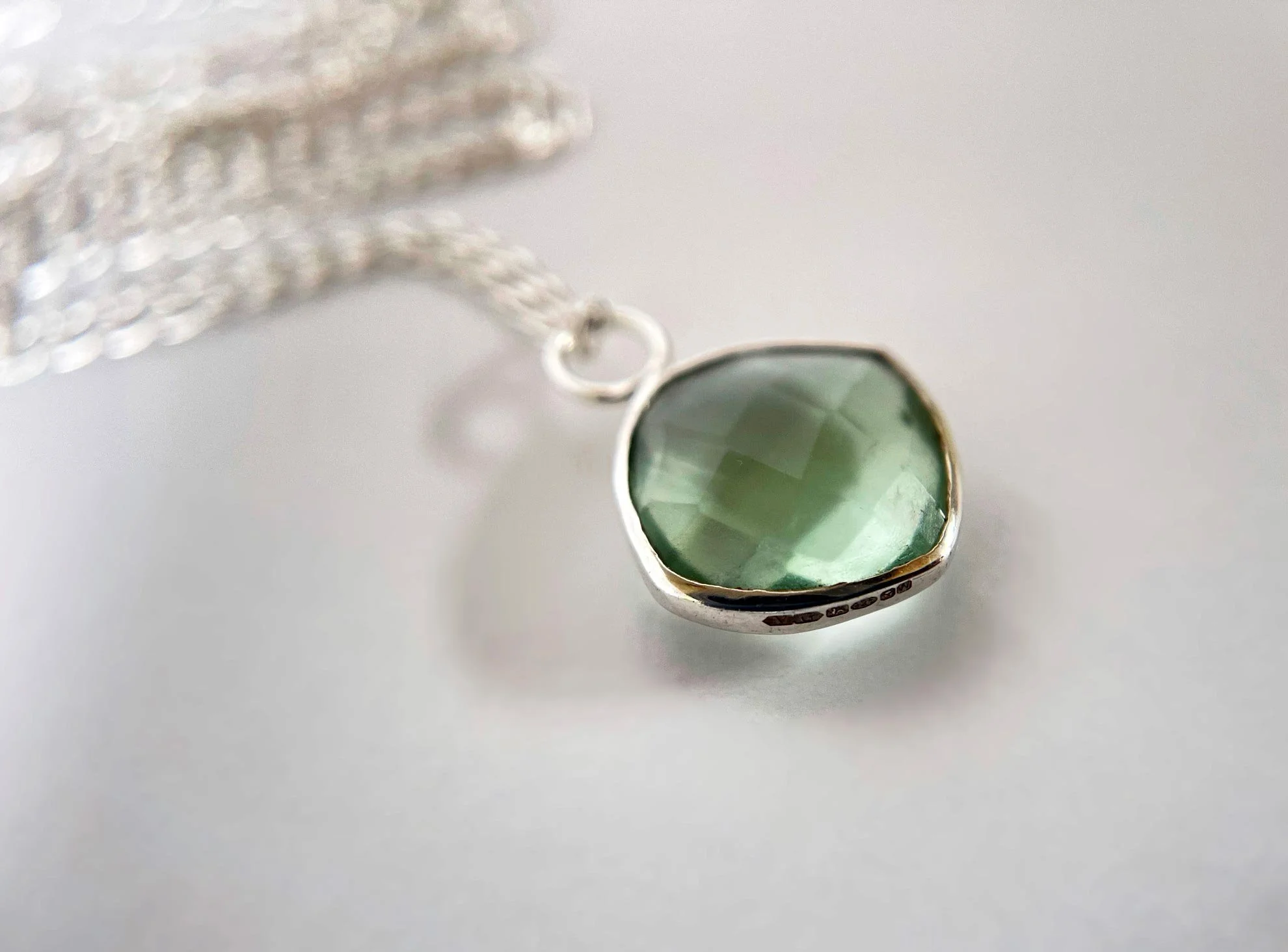 checker cut green flourite pendant silver chain white background