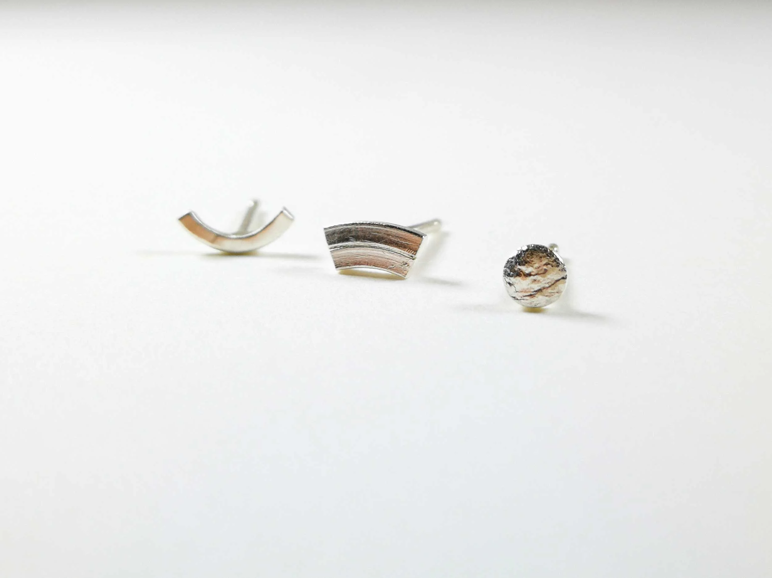Mismatched triplet earring set on white background handmade by victoria grace silversmith