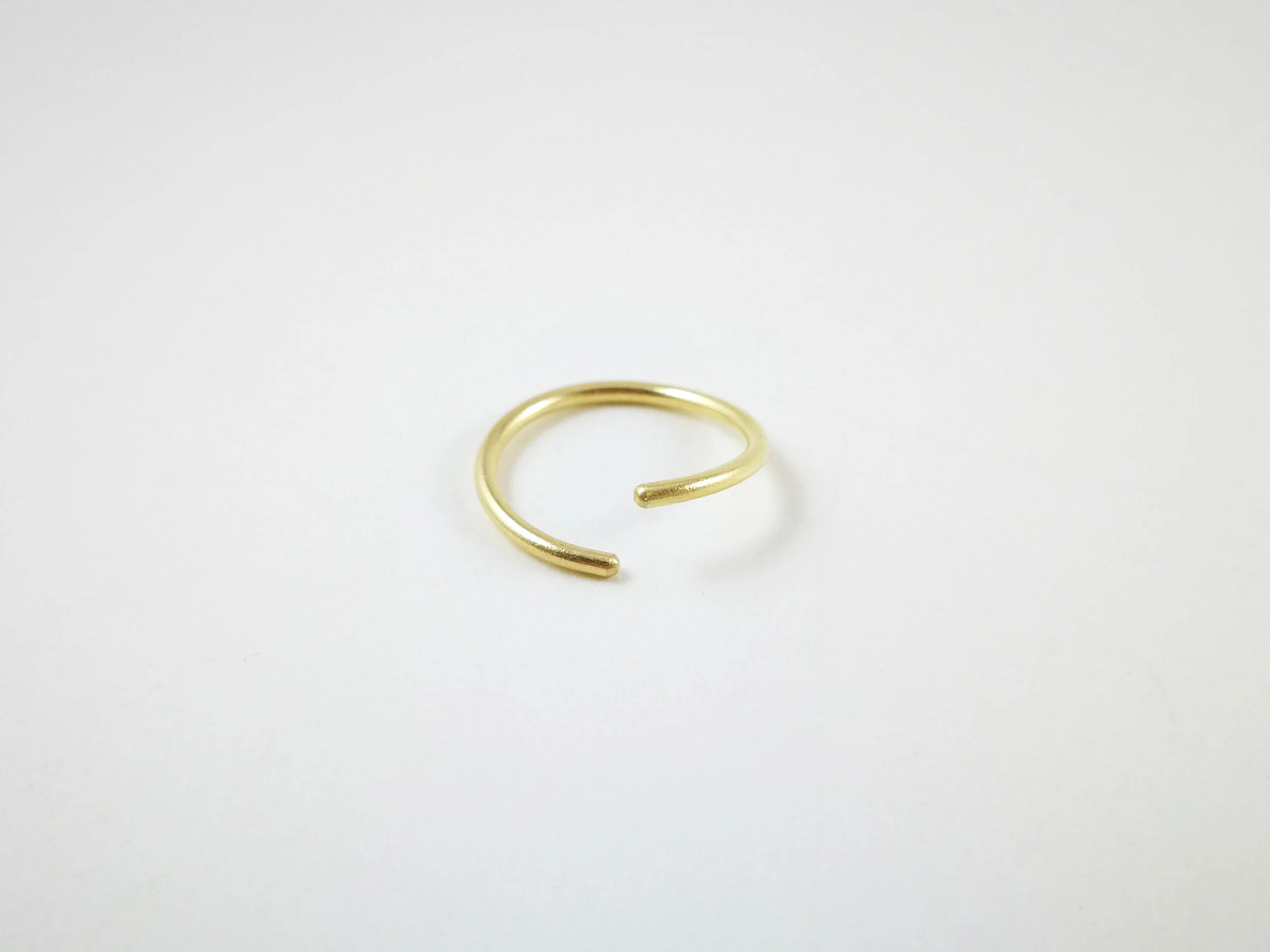 Solid gold endless hoop conch ring on white background
