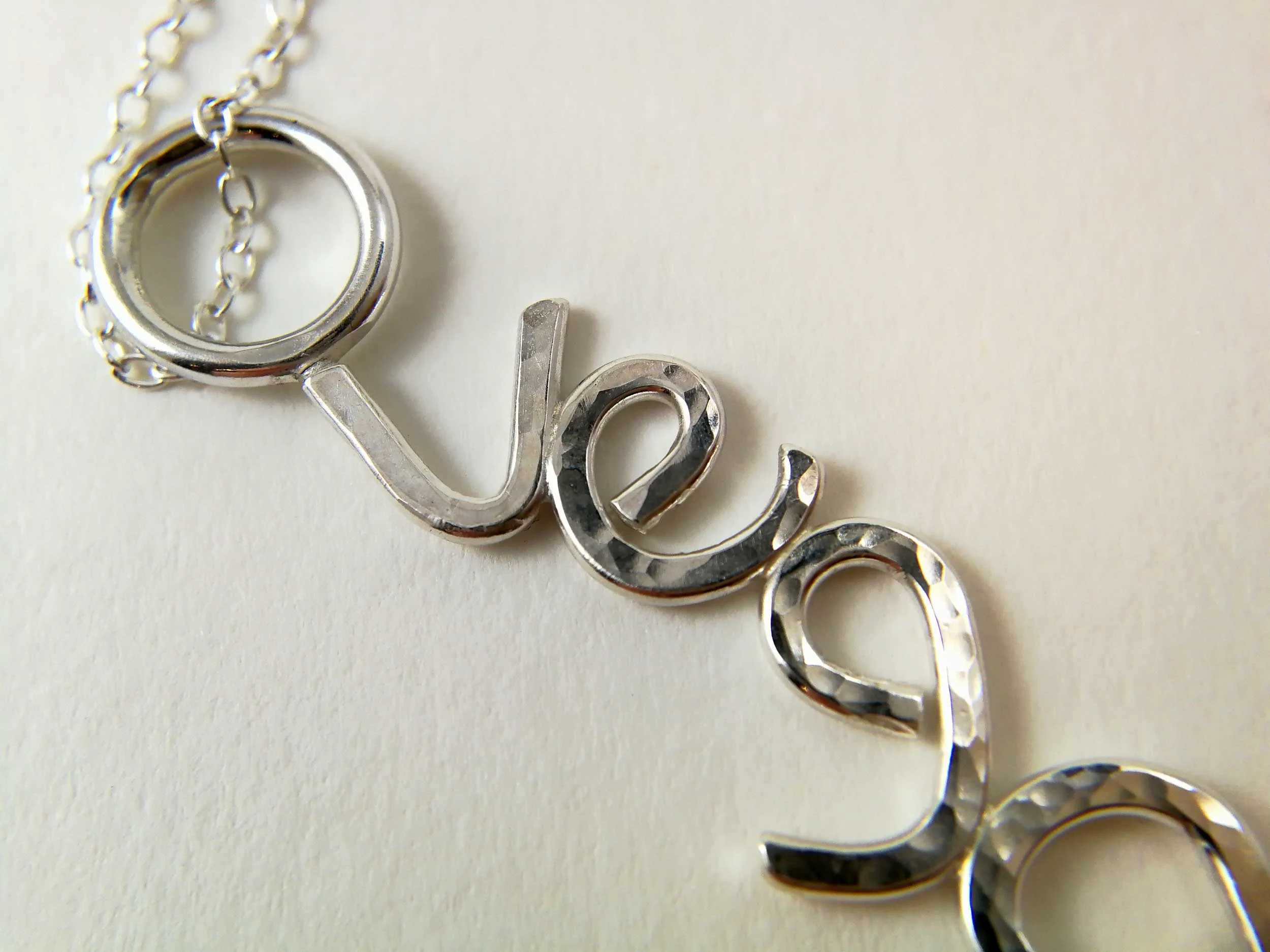 handmade silver vegan necklace close up white background