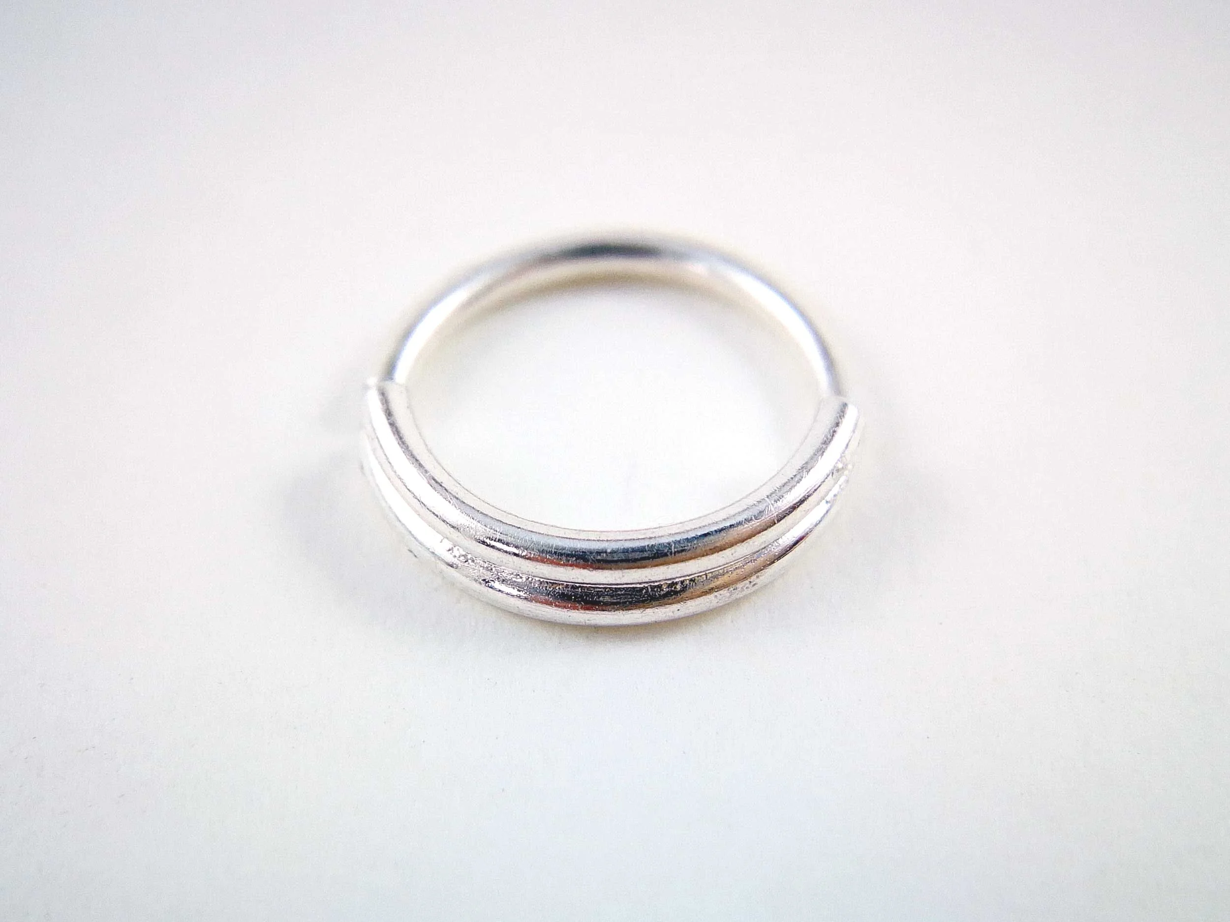 handmade silver helix hoop on white background