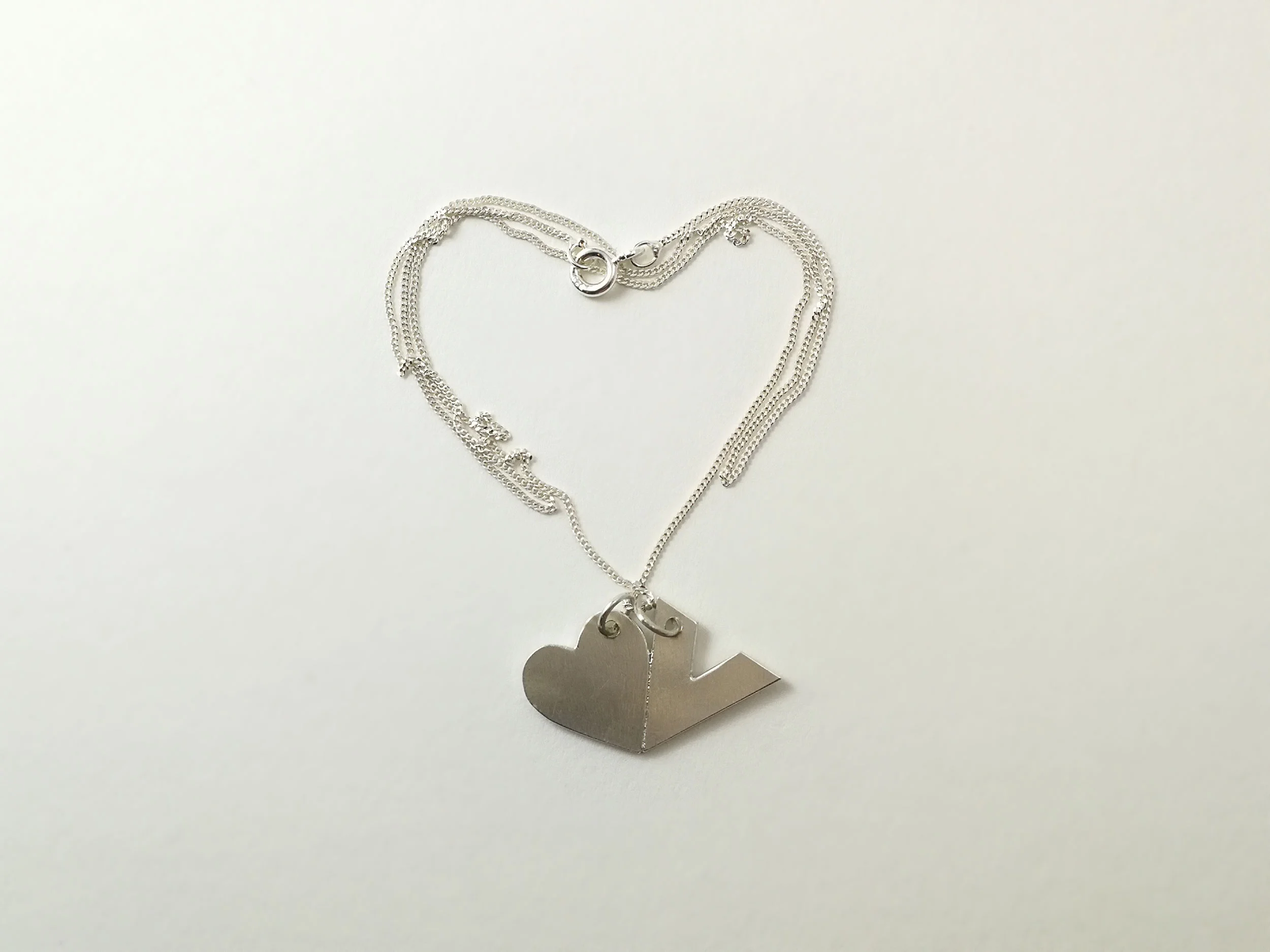 handmade silver heart necklace on white background victoria grace silversmith