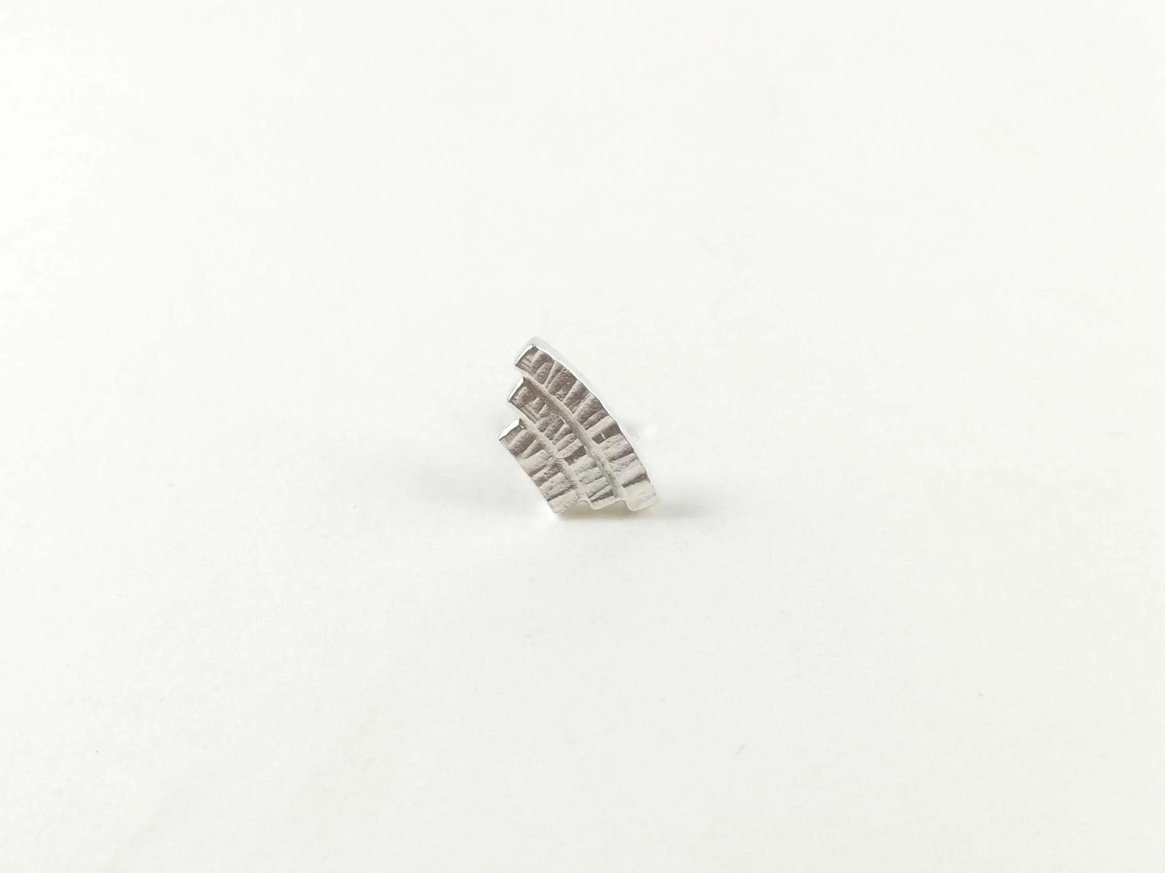 Recycled silver conch earring on white background product photo