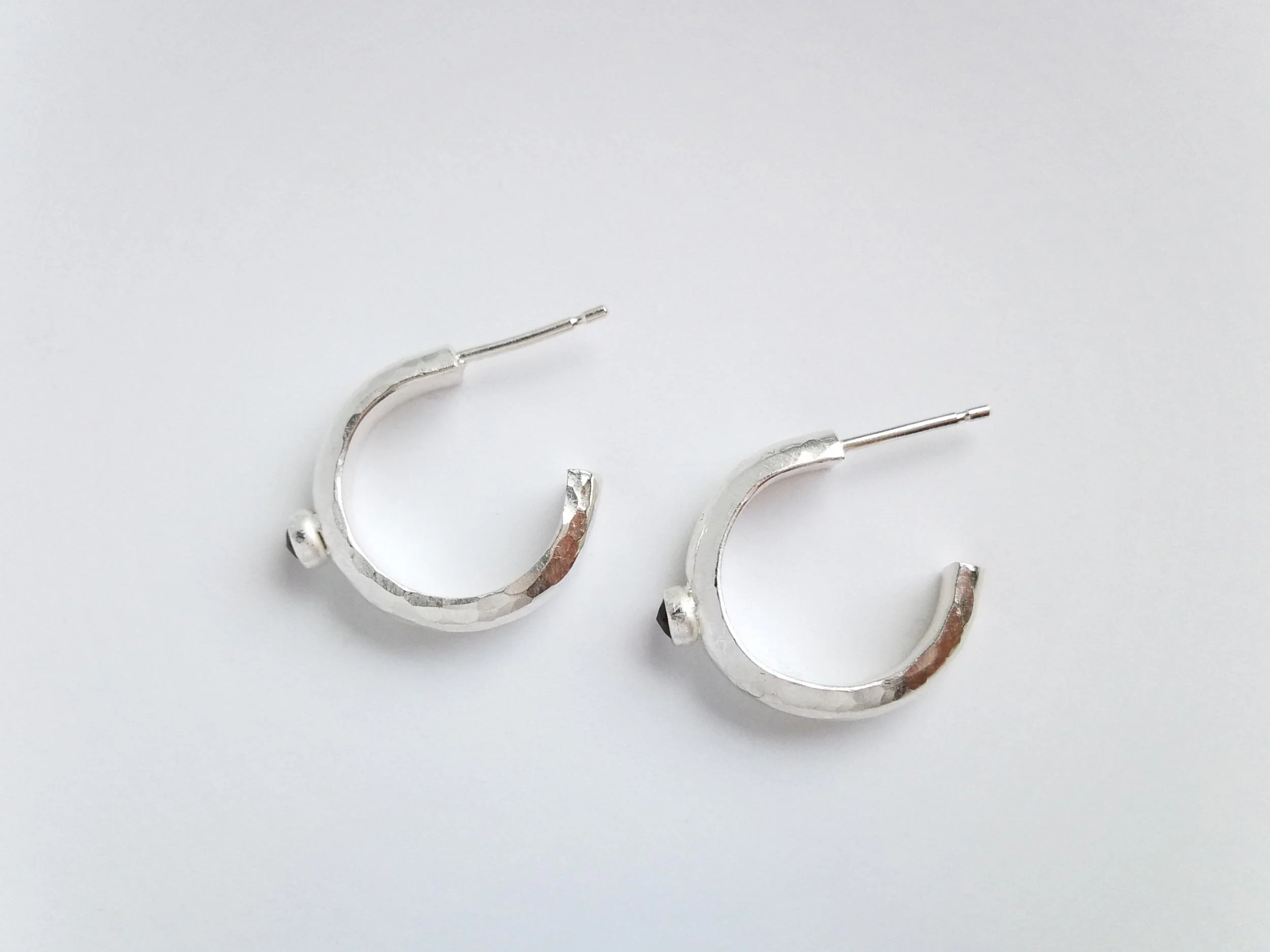 Recycled silver hoop earrings on white background
