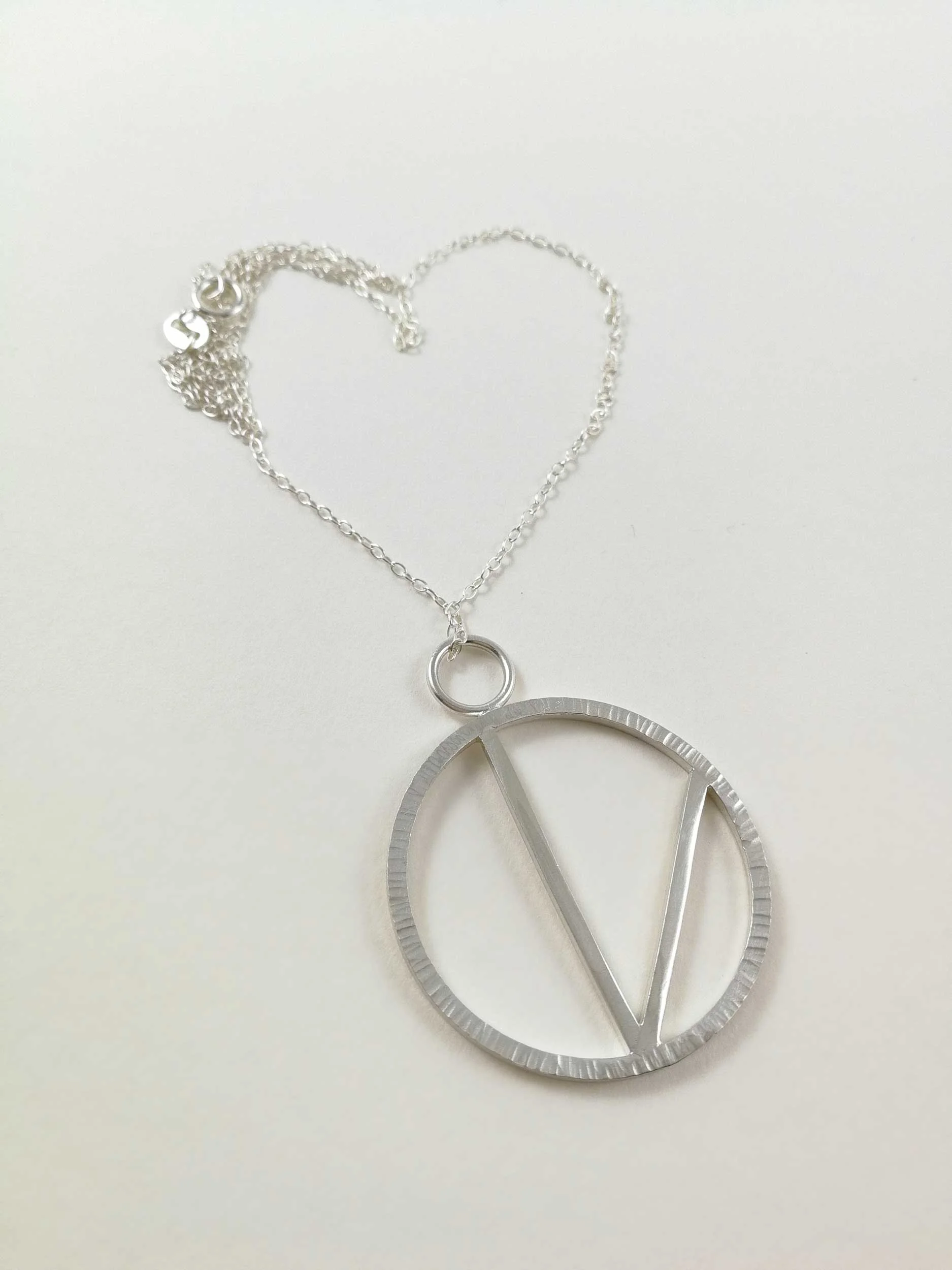 handmade Vegan V pendant on white background