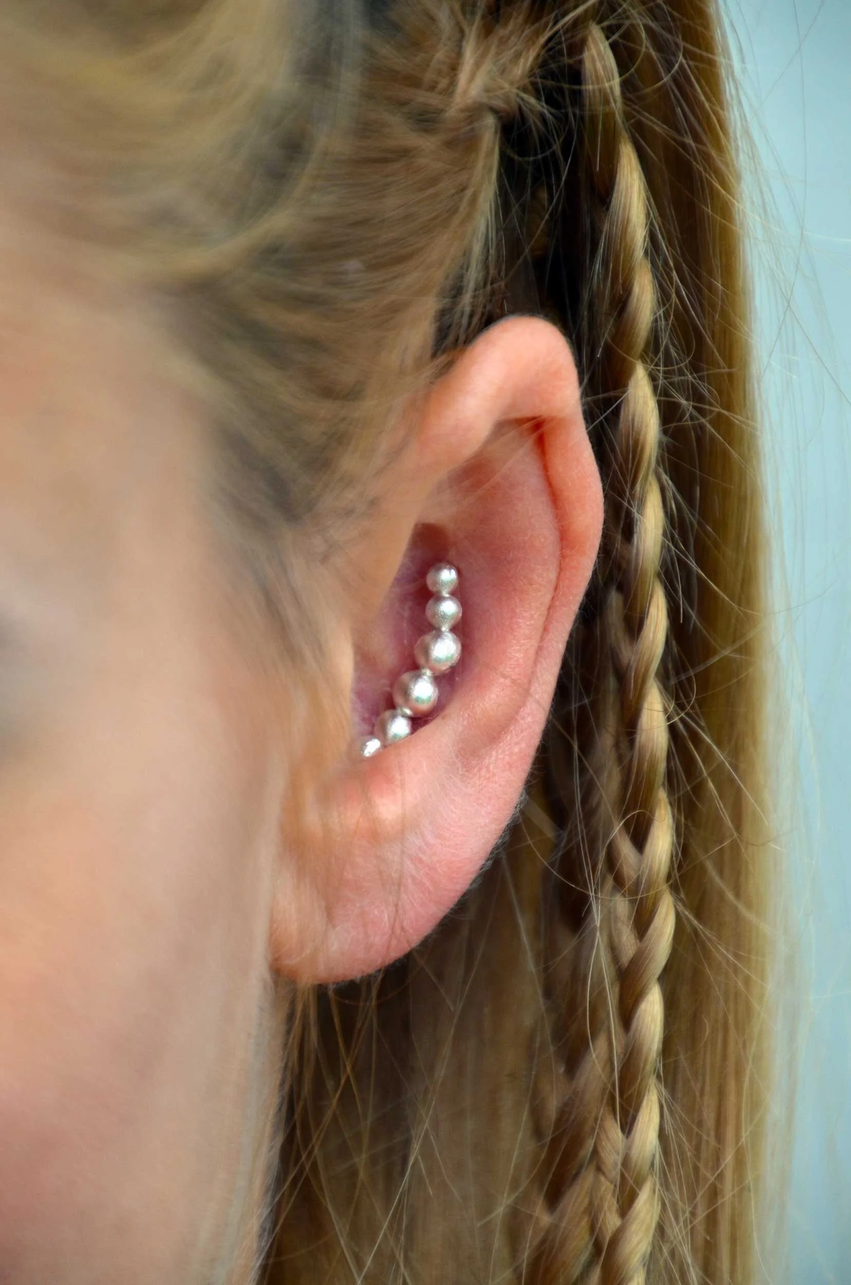 Handmade sterling silver conch earring on model