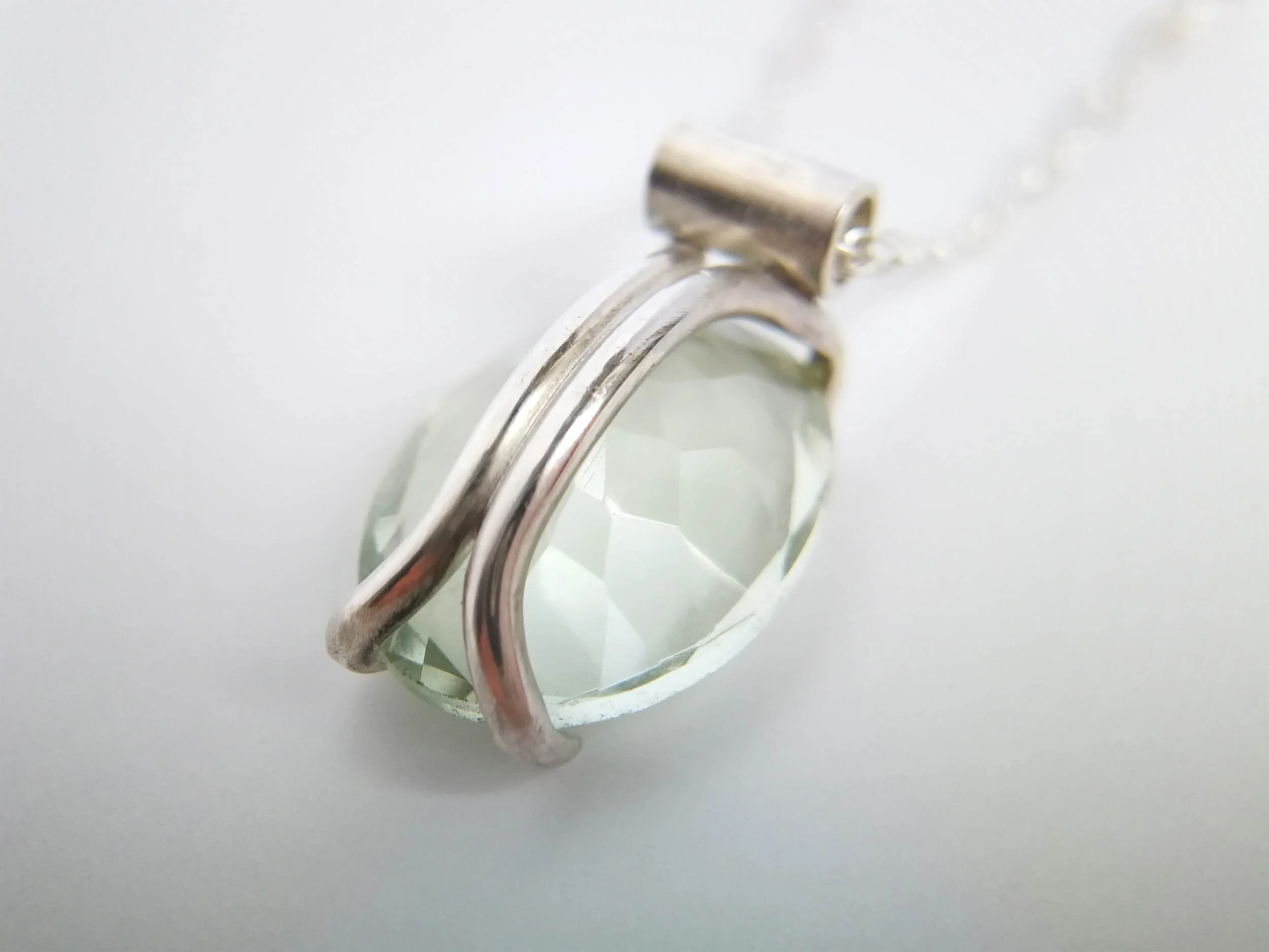 Green amethyst pendant with bespoke setting on white background