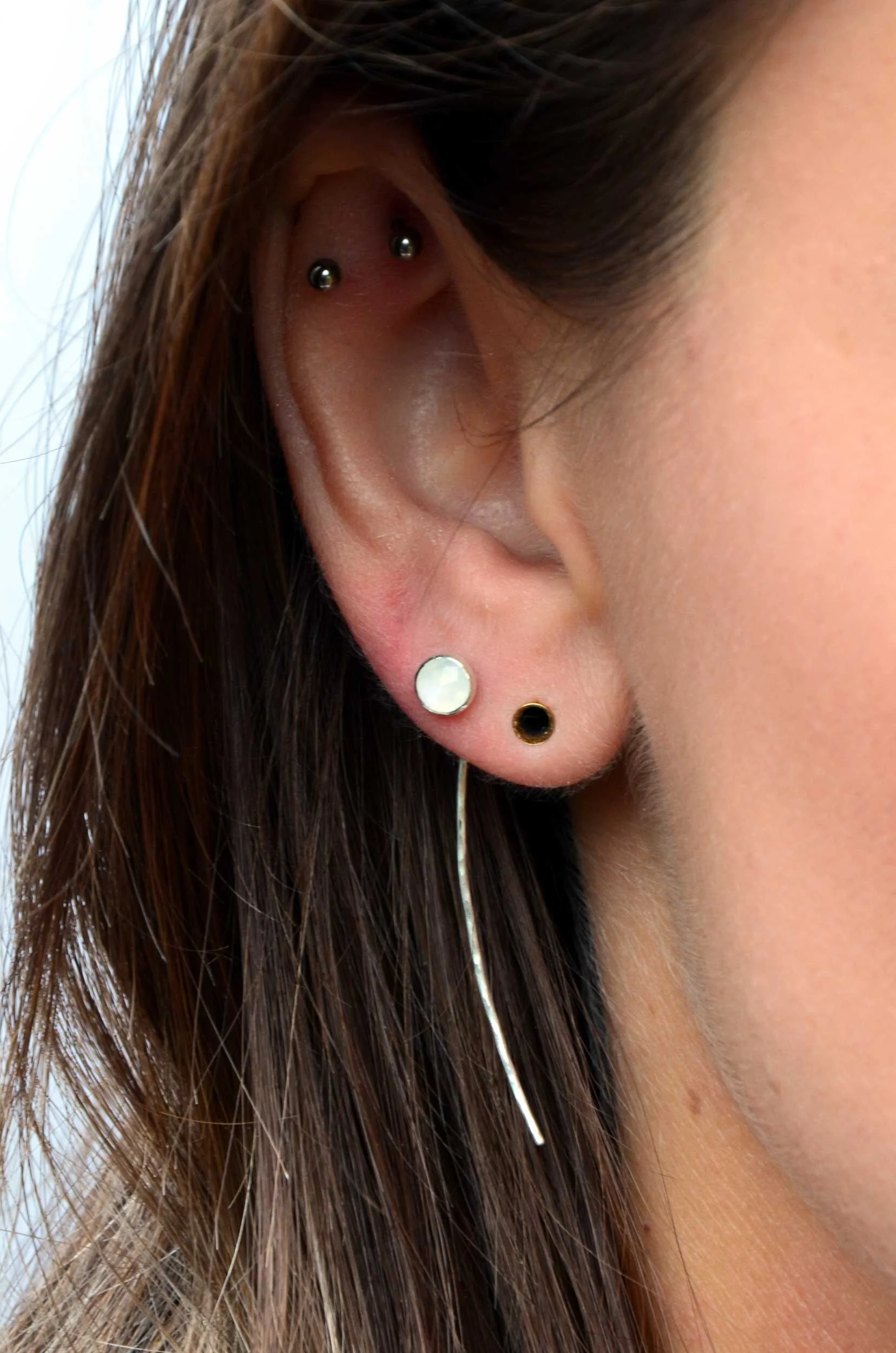 Handmade mismatched moonstone and chalcedony earrings on model