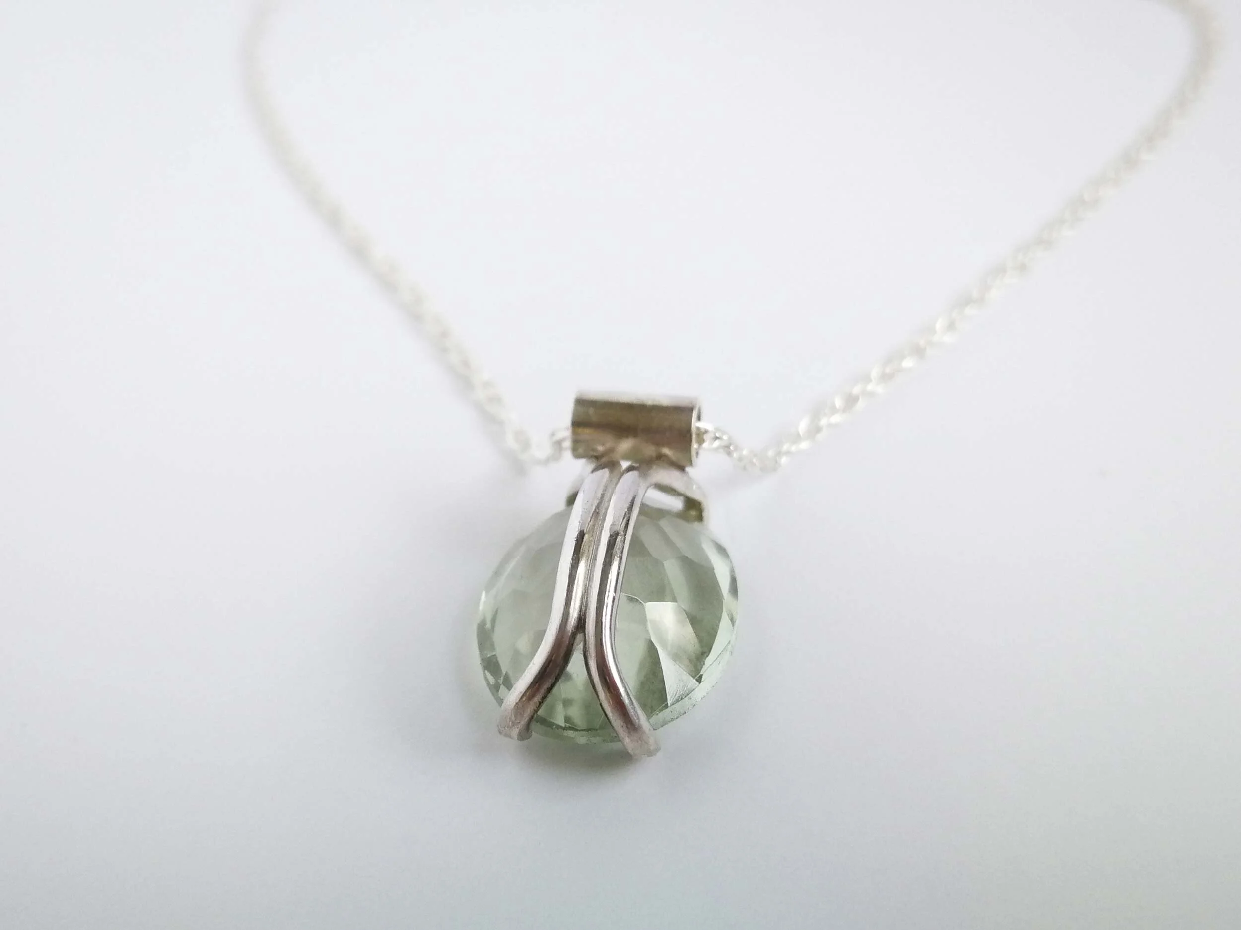 Claw set amethyst pendant on white background