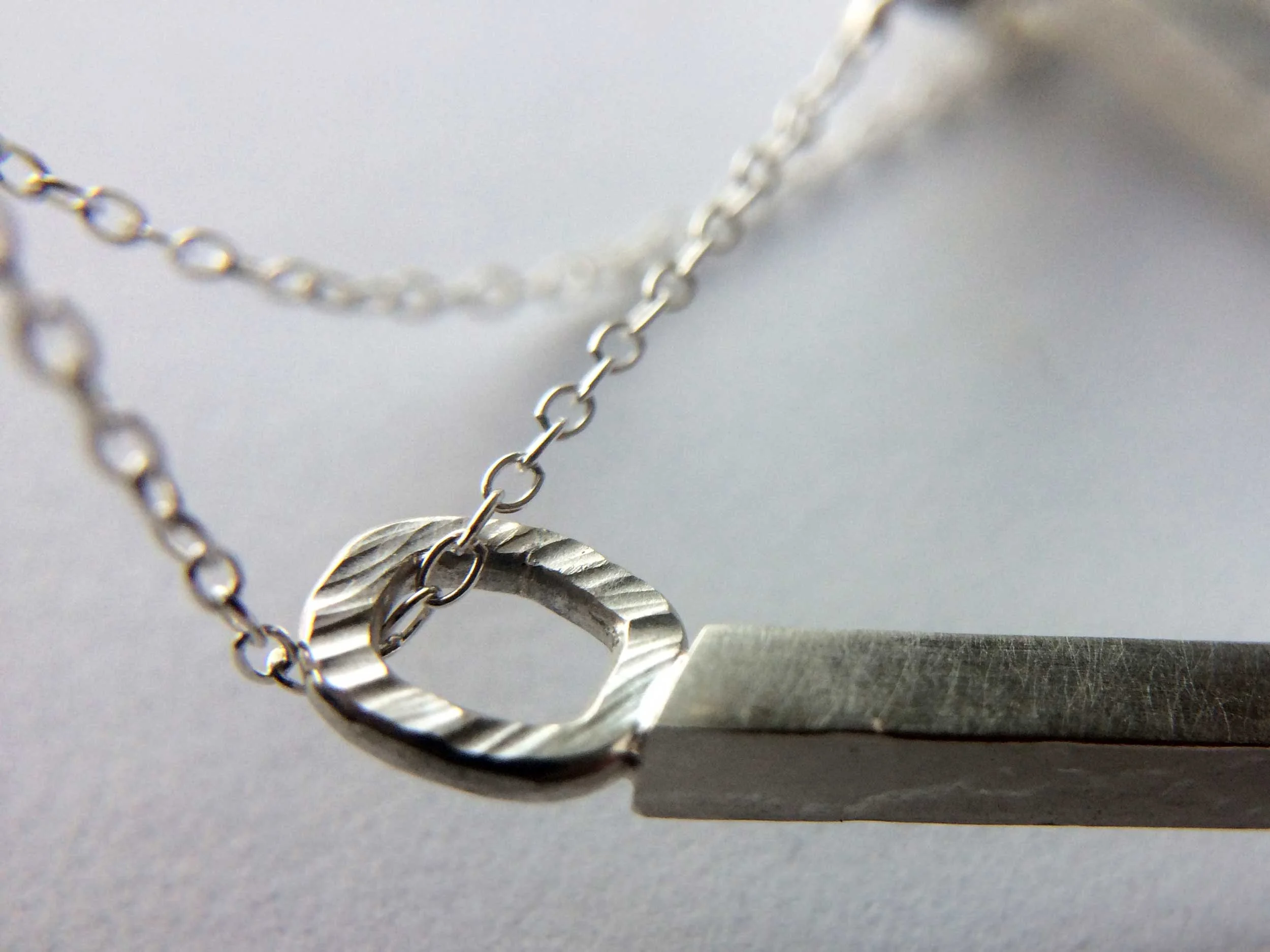 close up handmade silver pendant victoria grace white background