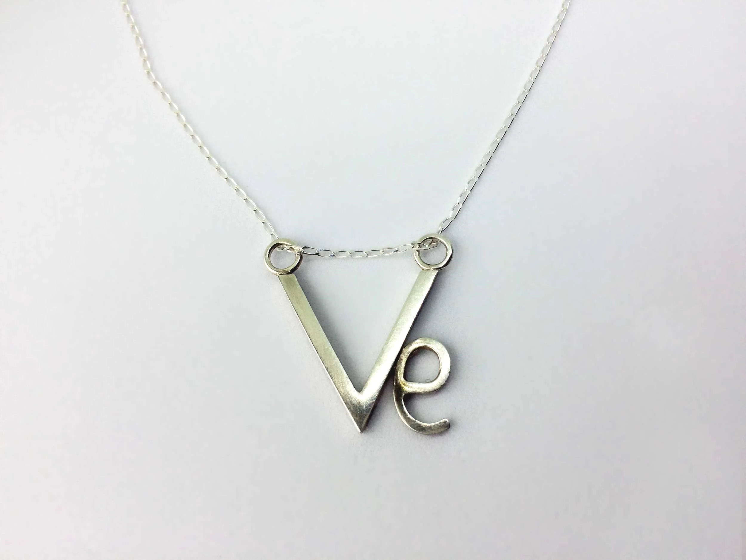 Handmade silver vegan pendant on white background victoria grace siversmith