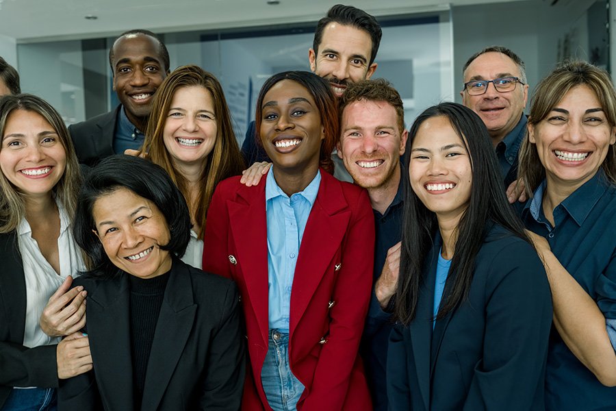 Group of diverse smiling professionals in a modern office setting.