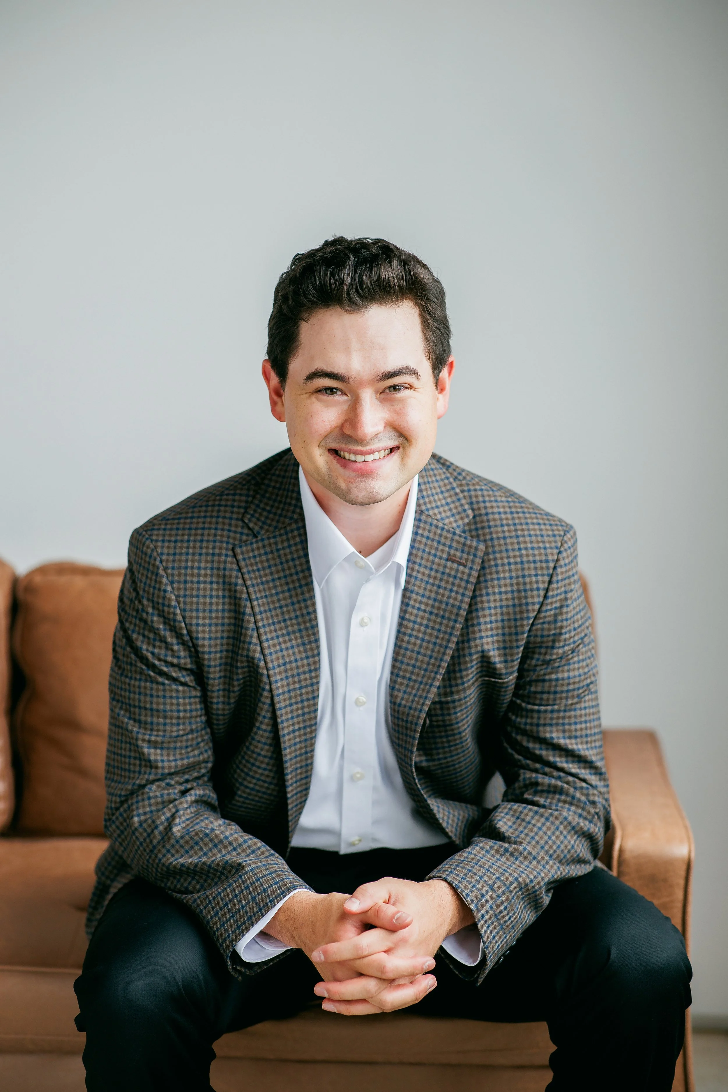 Professional saxophone player Landon Chang wearing a checkered blazer, smiling during a press headshot session in Rochester