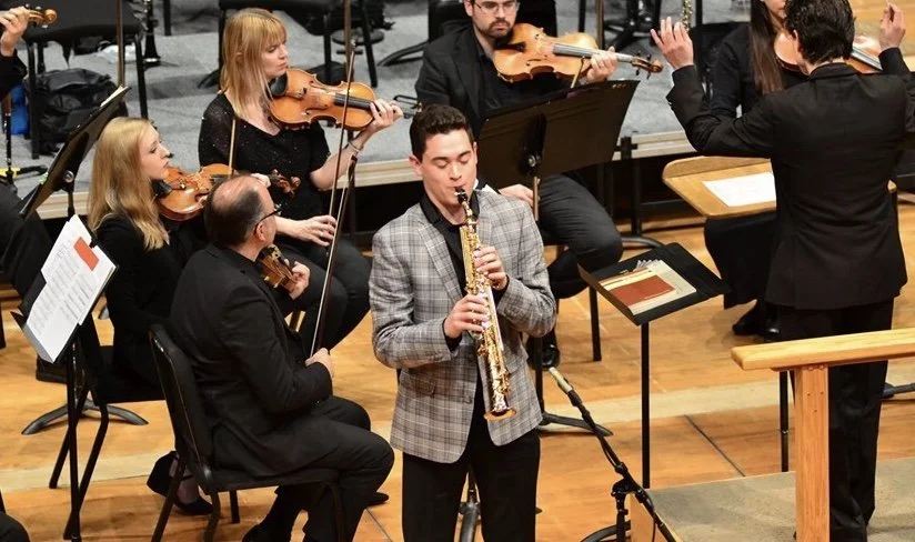 Landon Chang performing as a featured soprano saxophone soloist with the Spokane Symphony Orchestra on a concert stage