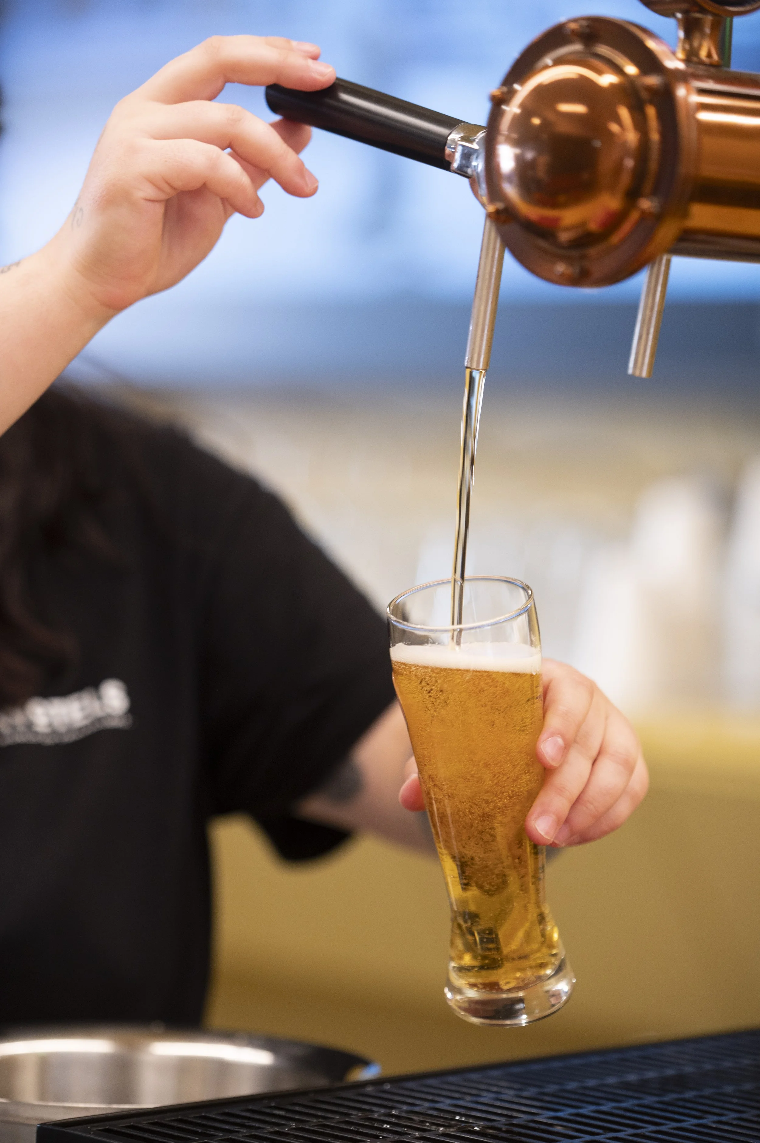 Pessoa servindo cerveja para um copo em um bar
