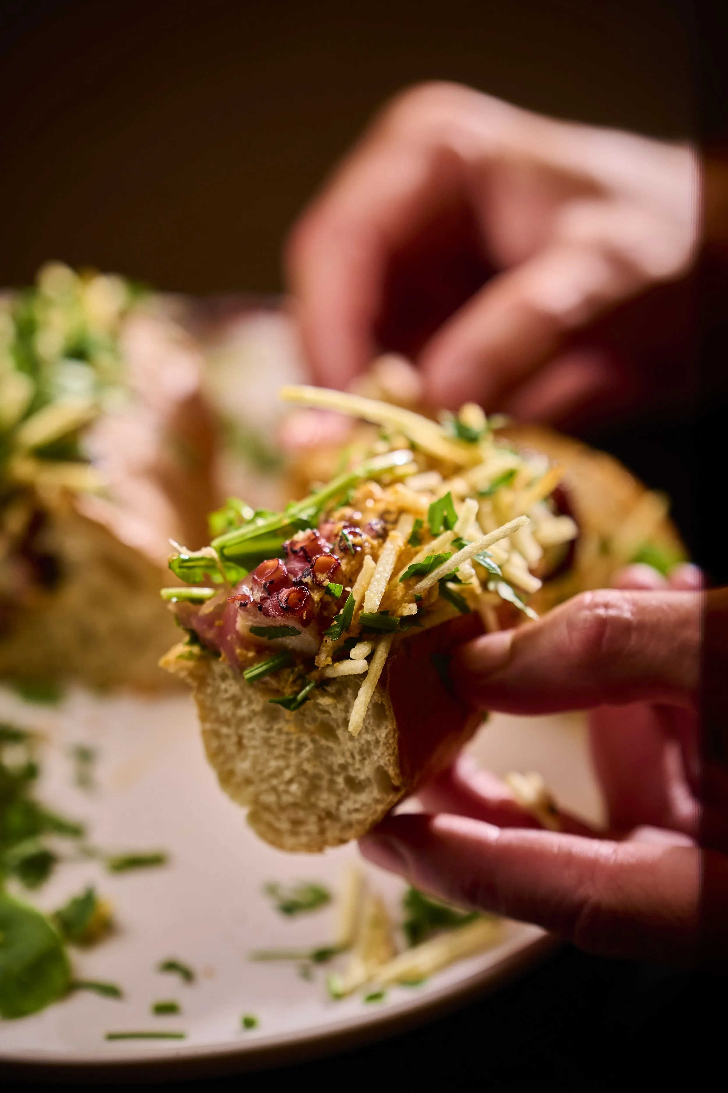 Pessoa segurando uma taça de torta com recheio de carne, queijo, alface, tomate e queijo ralado, decorada com cheiro-verde.