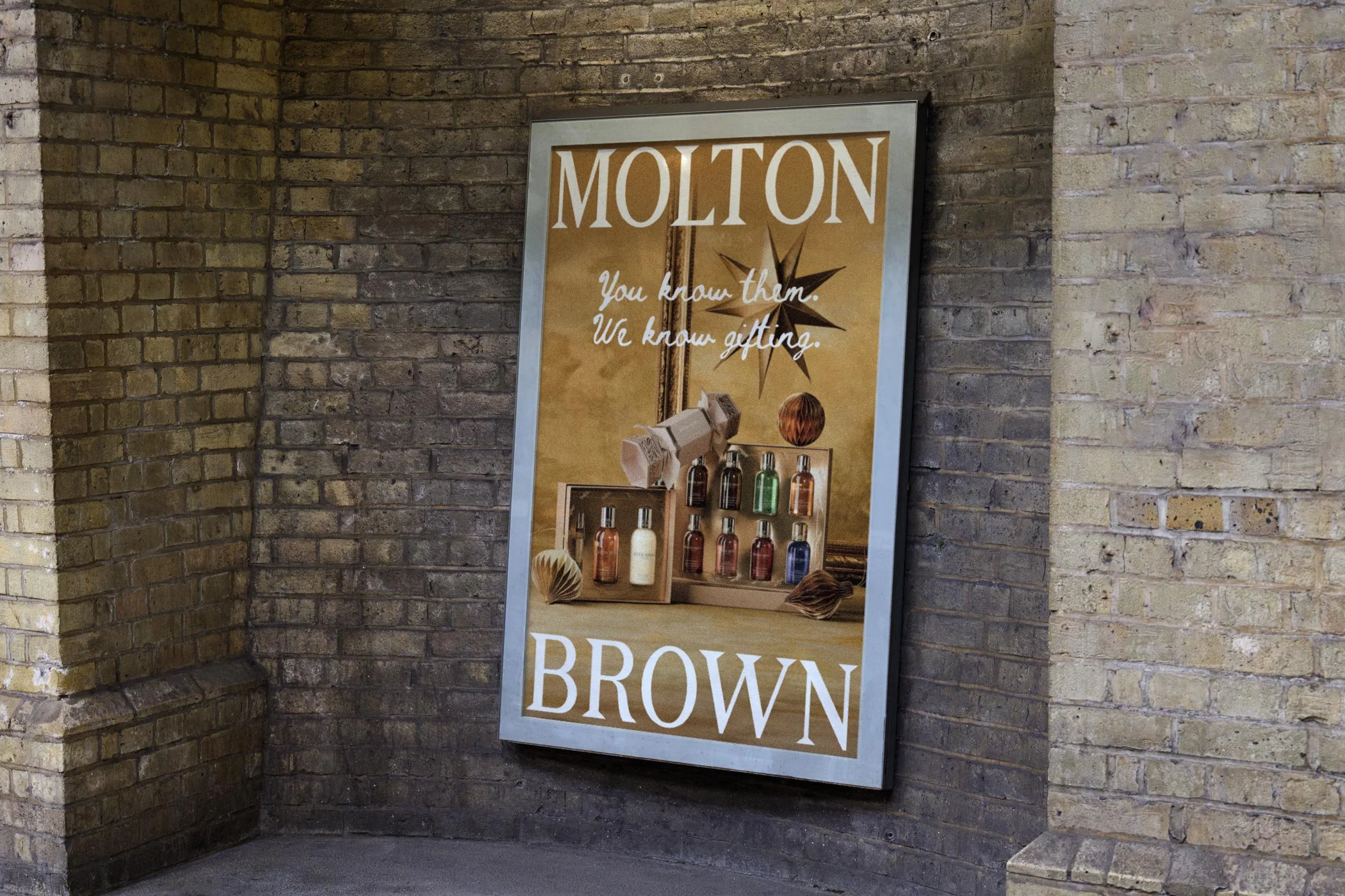 Outdoor poster placement for Molton Brown You Know Them, We Know Gifting Christmas campaign in a London-style streetscape.