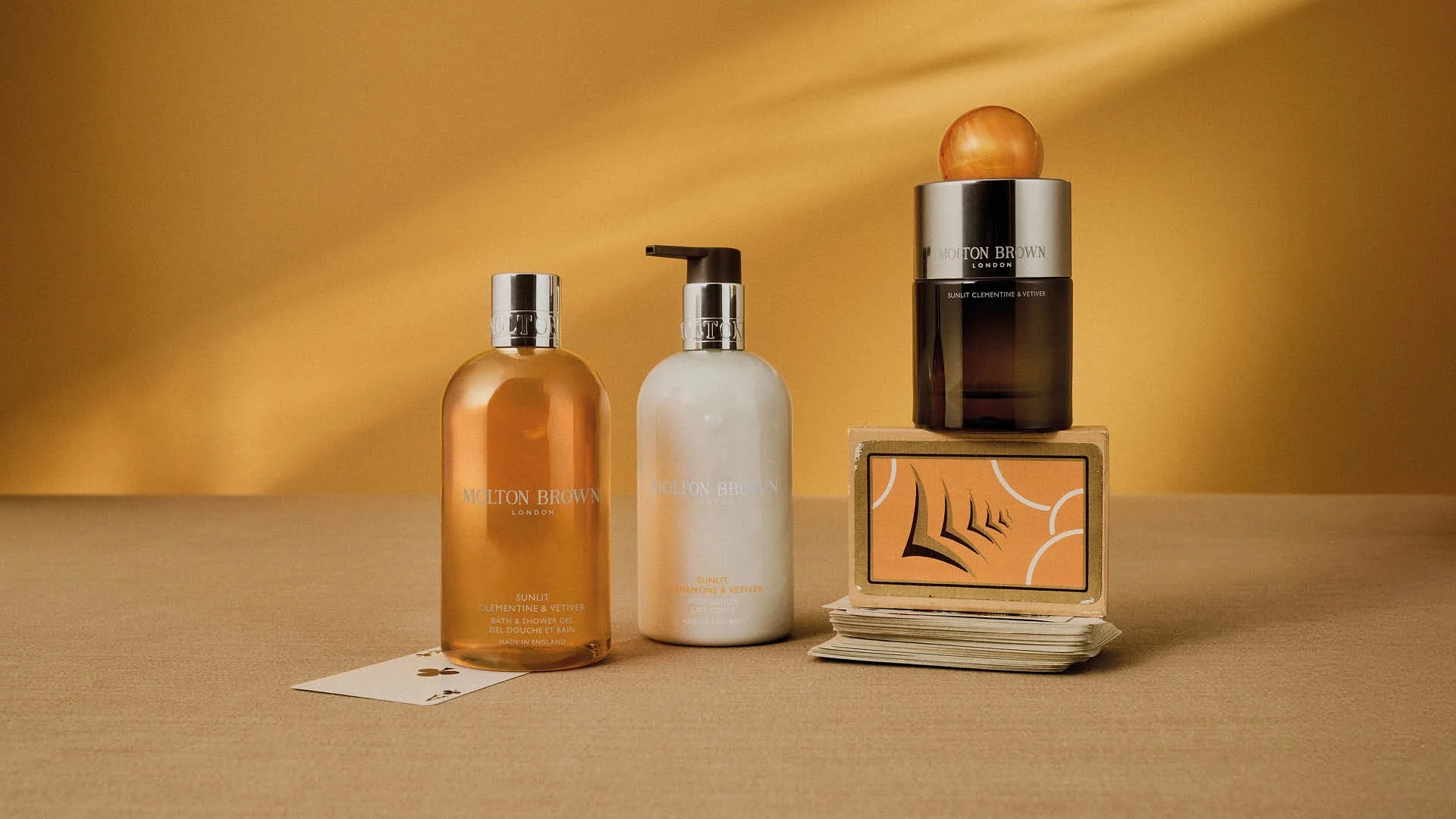 Molton Brown fragrance collection styled within a cohesive Evergreen colour system using a tonal backdrop.