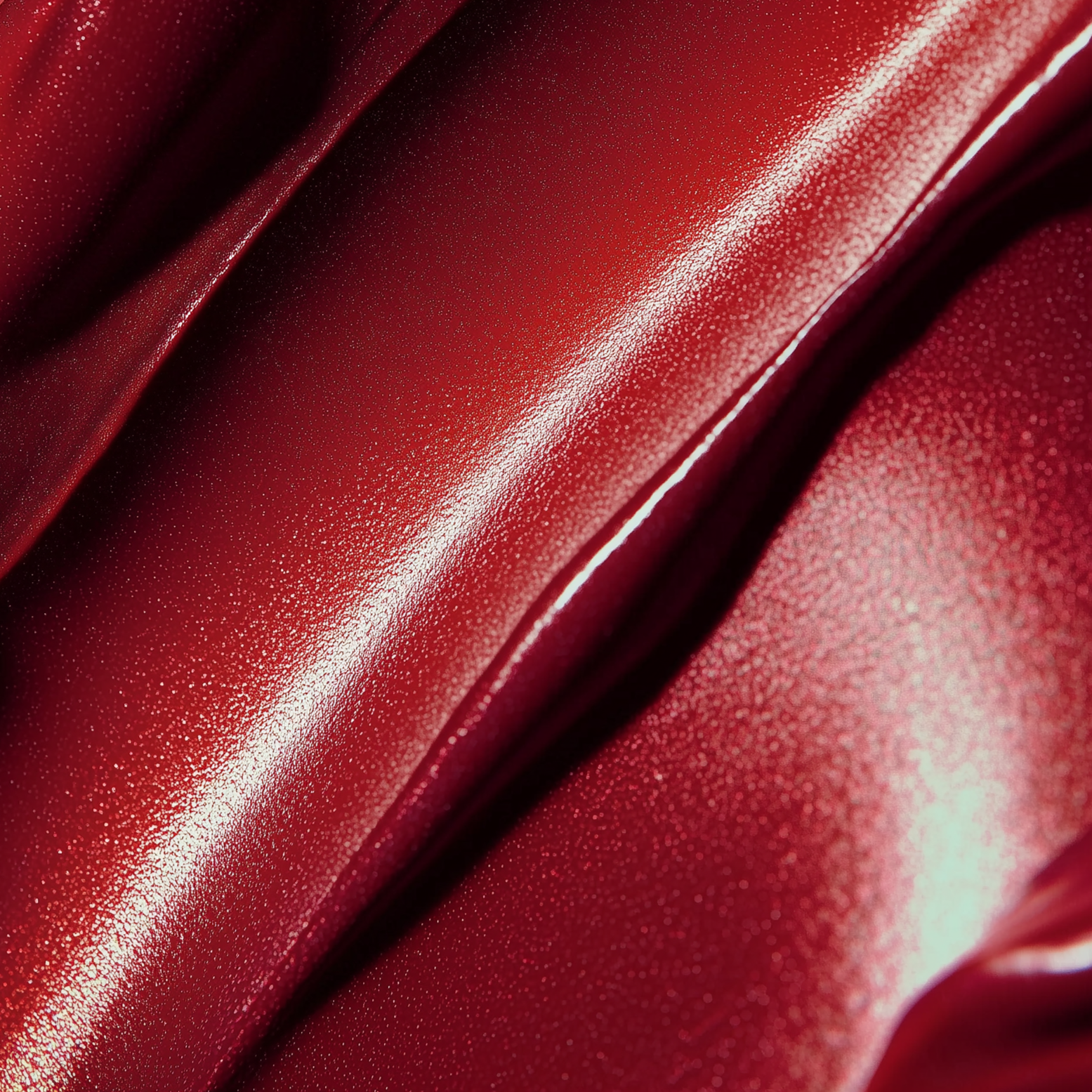 Close-up of red satin fabric with shiny and textured surface.