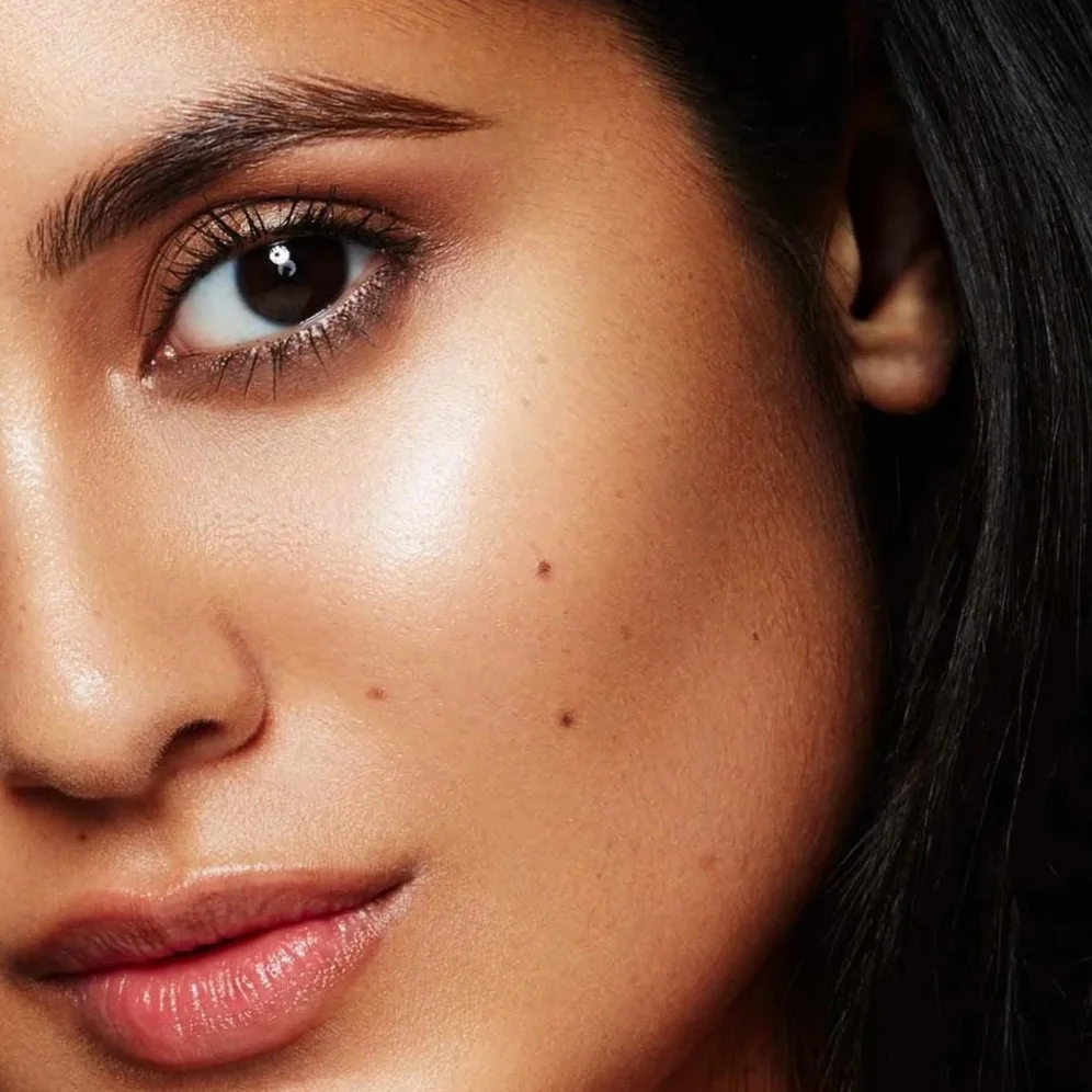 Close-up of a woman's face showing her eye, cheek, lips, and part of her hair.