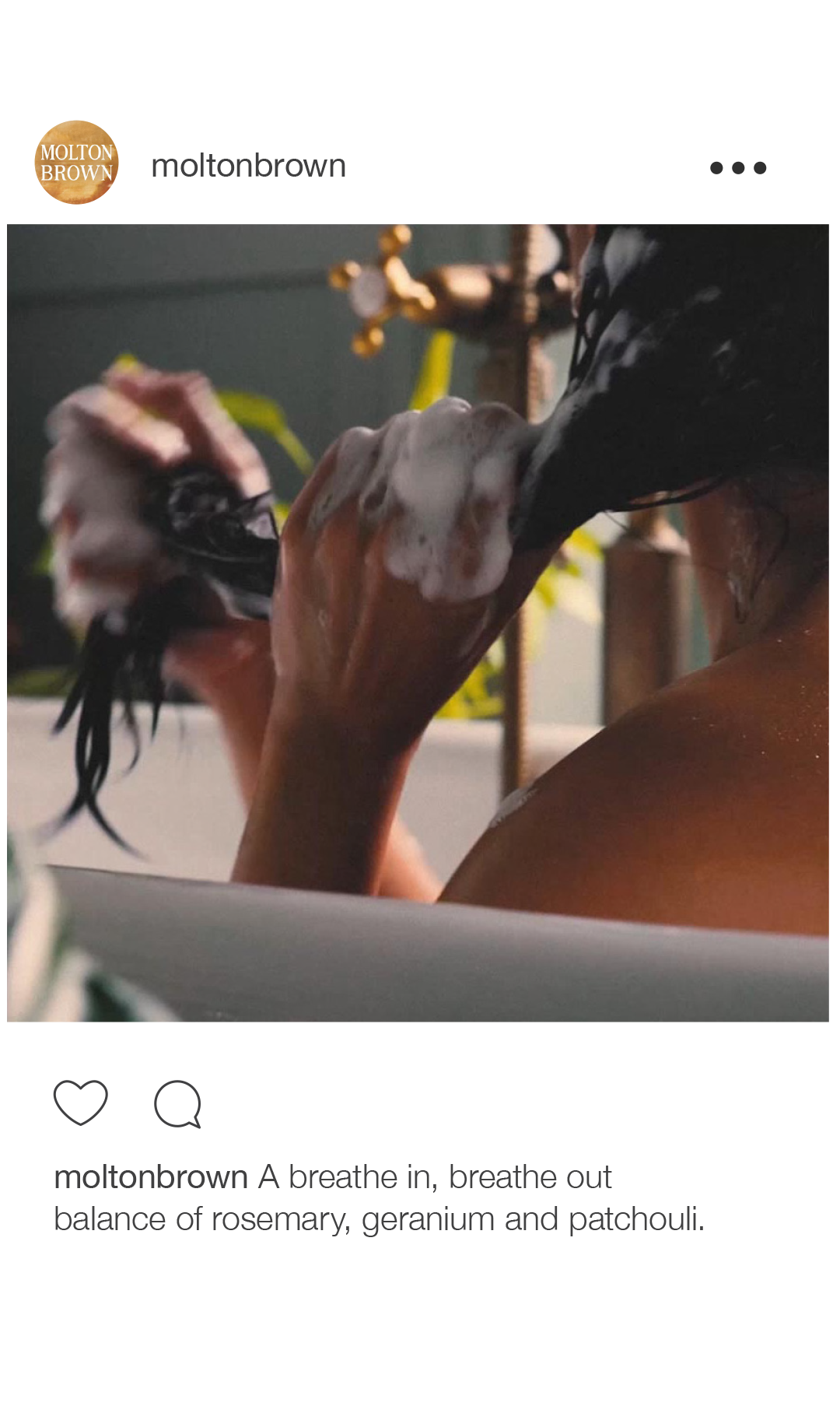 Person taking a bath, lathering soap on their arm with soap bubbles, in a dimly lit bathroom.