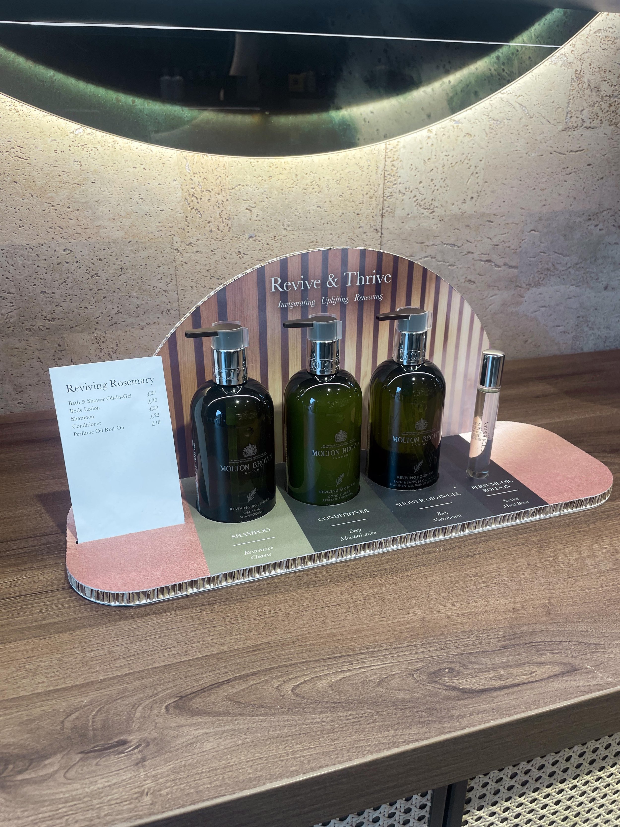 Display of Molton Brown skincare products on a wooden table with a promotional sign.