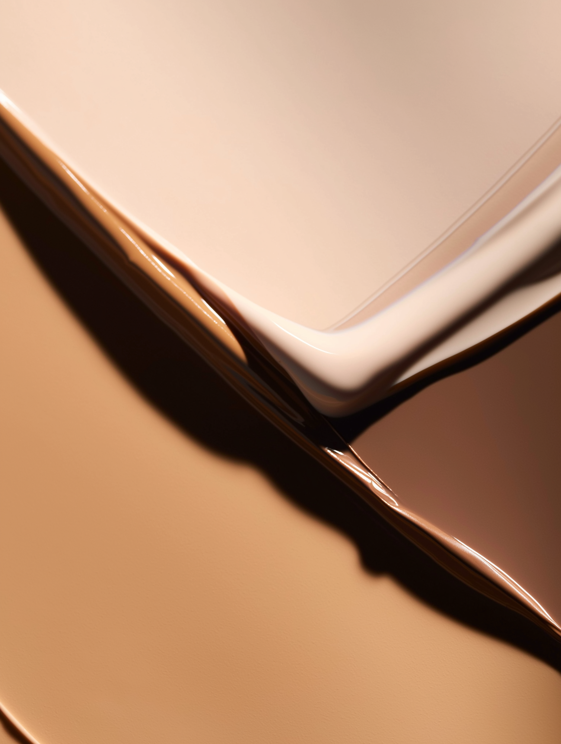 Close-up of a corner of an electronic device, possibly a smartphone, with a sleek design and metallic edges placed on a beige surface.
