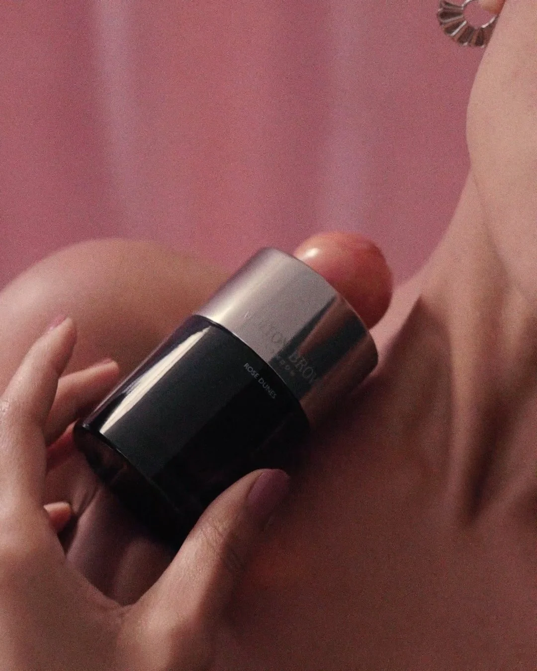 Close-up of fragrance rollerball applicator on skin