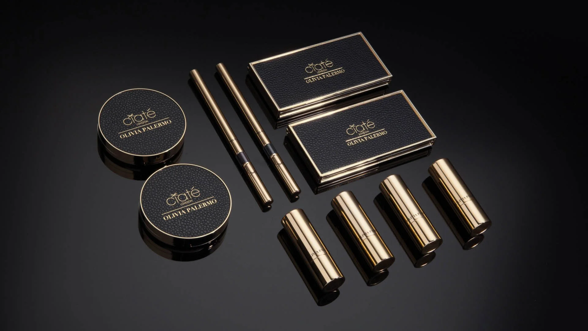 Flatlay of hero makeup products from the Ciaté London x Olivia Palermo collection including palettes, compacts and lipsticks.