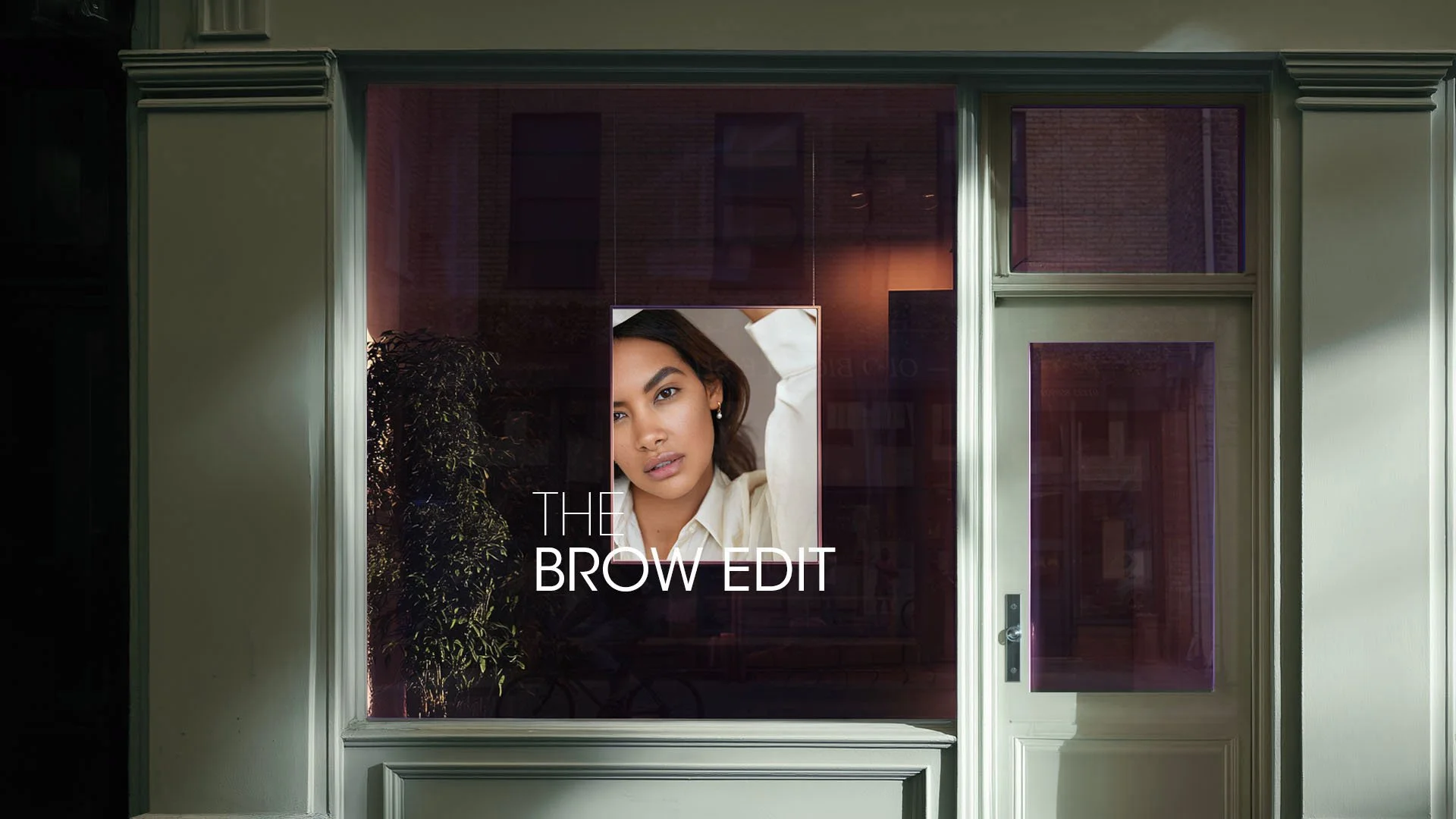 Storefront window display with The Brow Edit campaign signage