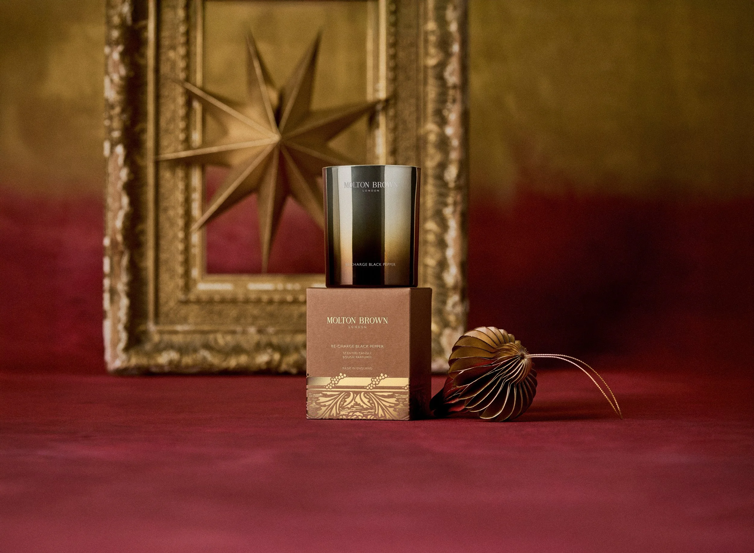 Still life product composition from Molton Brown Christmas gifting campaign featuring sculptural festive props and warm metallic tones.