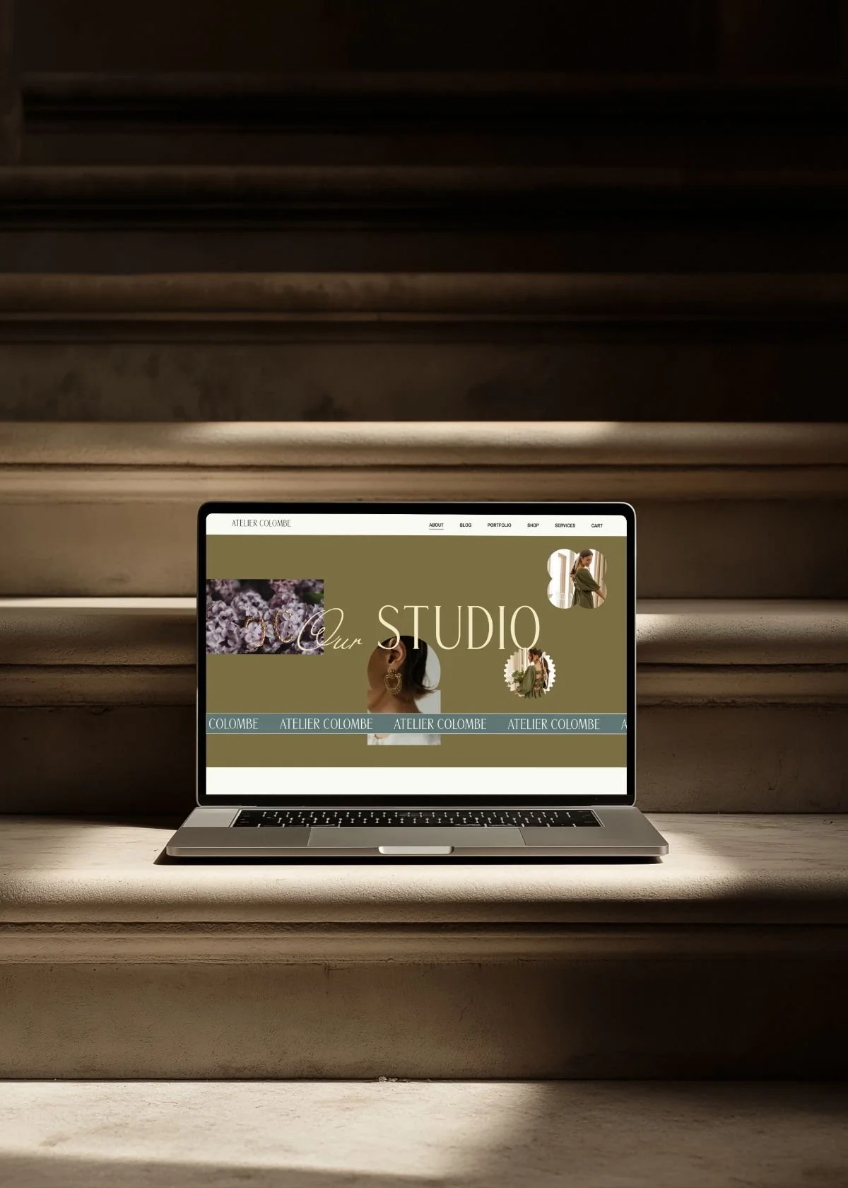 Laptop displaying the website of Atelier Colombe with images of jewelry and women, placed on a staircase.