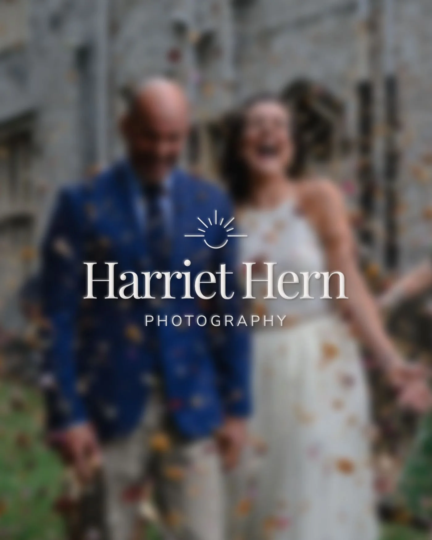 Blurry photo of a smiling couple holding hands outside near a stone wall.