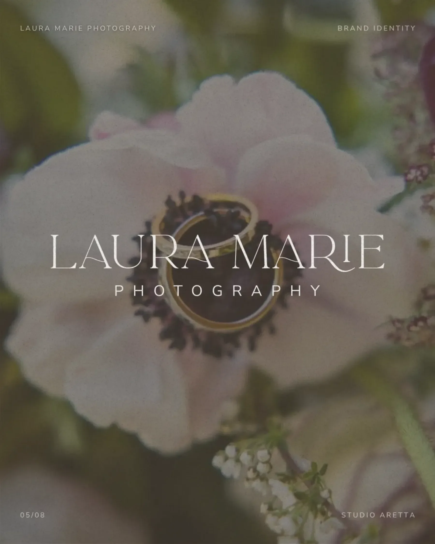 Close-up of a pale flower with two gold rings, perfect for wedding photographer branding. Laura Marie Photography overlay in center.