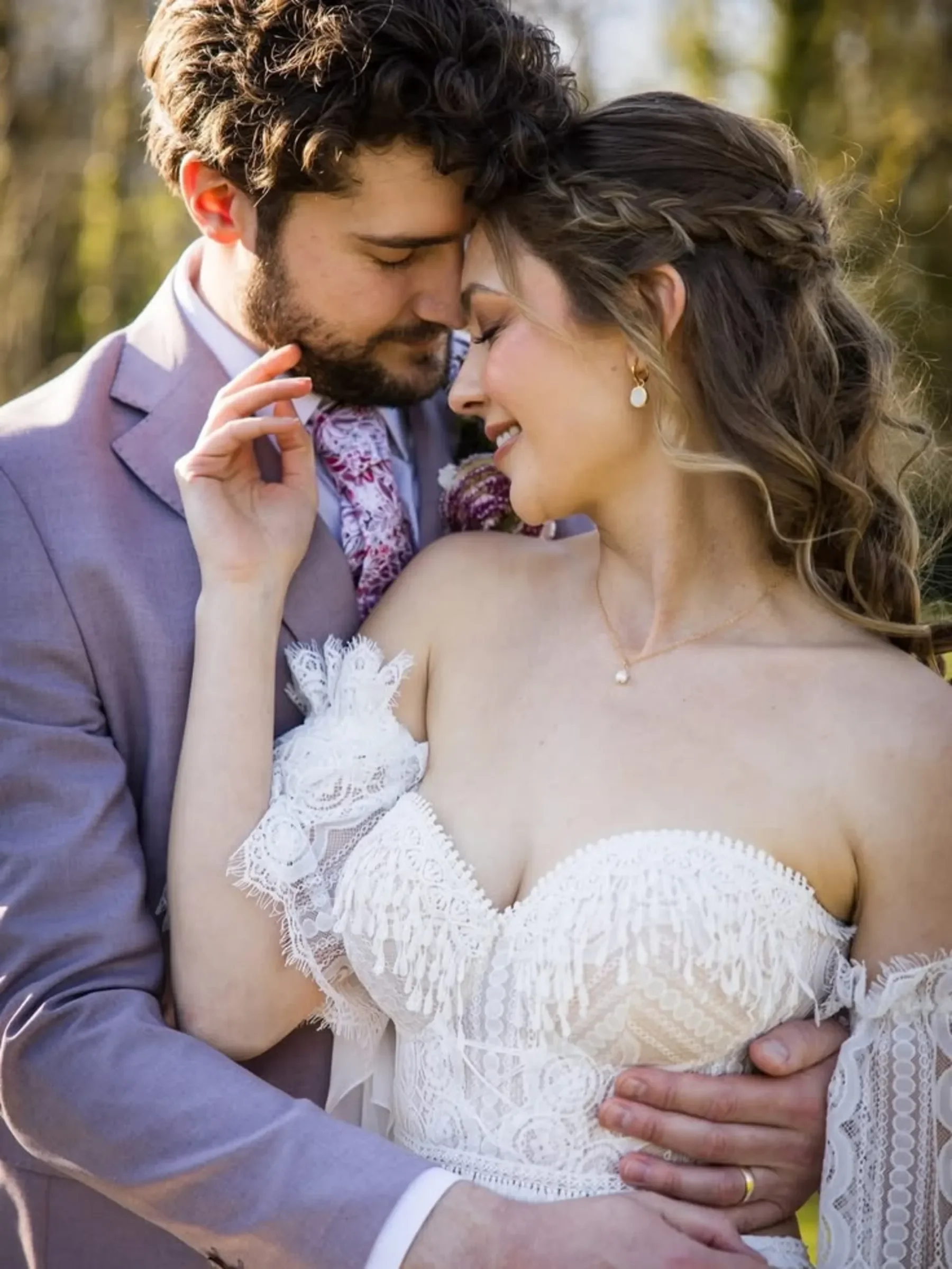 A bride and groom embrace outdoors, smiling lovingly in wedding attire—perfect inspiration for authentic wedding photographer branding.