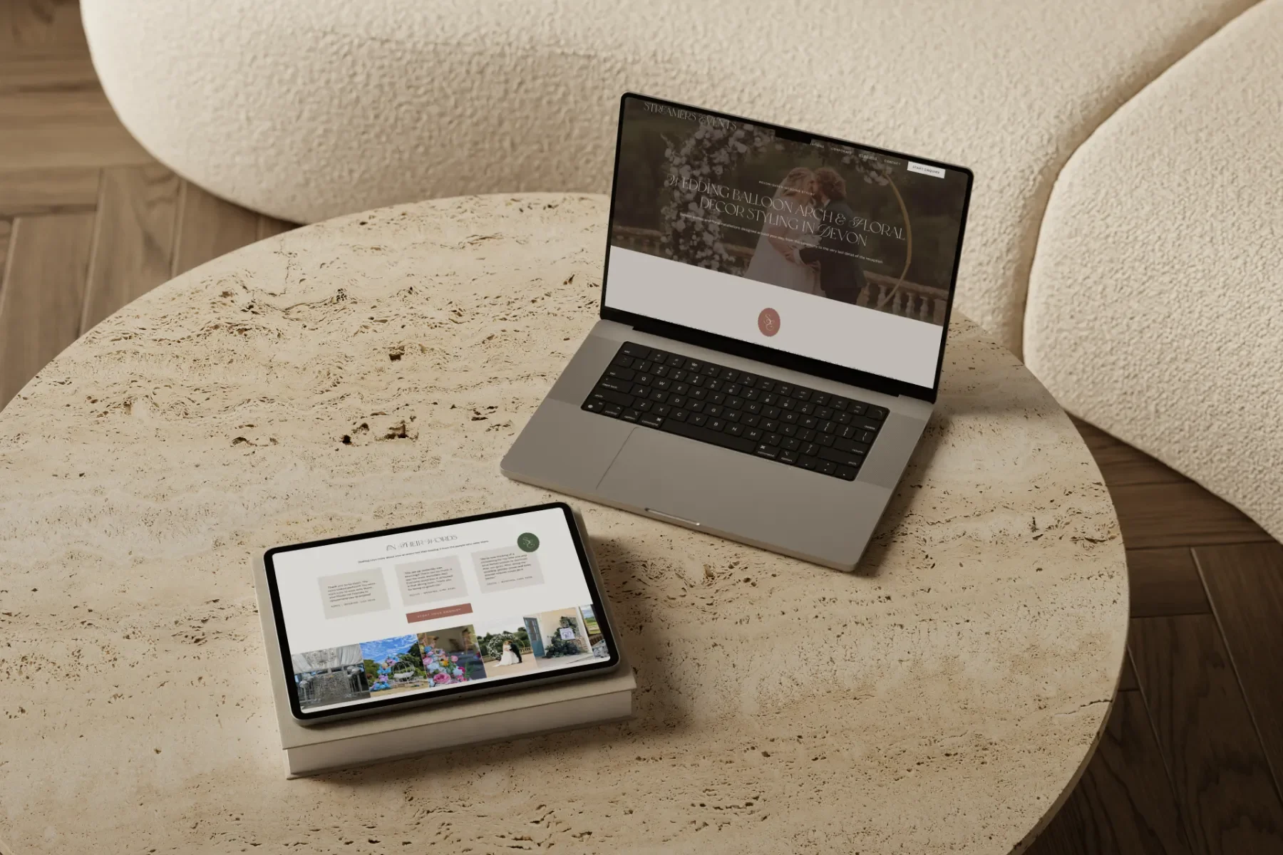 A laptop and tablet resting on a round stone table, both displaying a website for an event stylist brand.