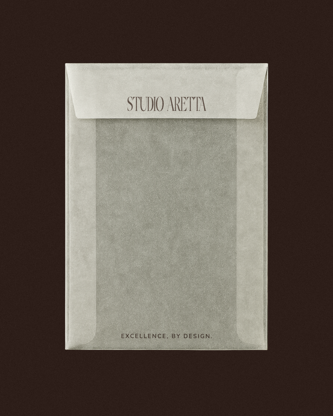 A sealed white paper envelope with the label "STUDIO ARETTA" at the top and the phrase "EXCELLENCE, BY DESIGN." at the bottom, placed on a dark background.