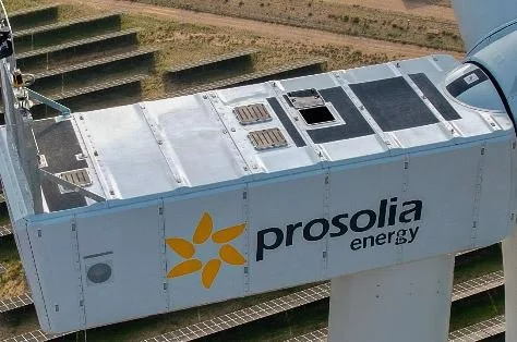 Vista de una estructura de tren o metro con logotipo de prosolia energy en el costado, en un entorno al aire libre.