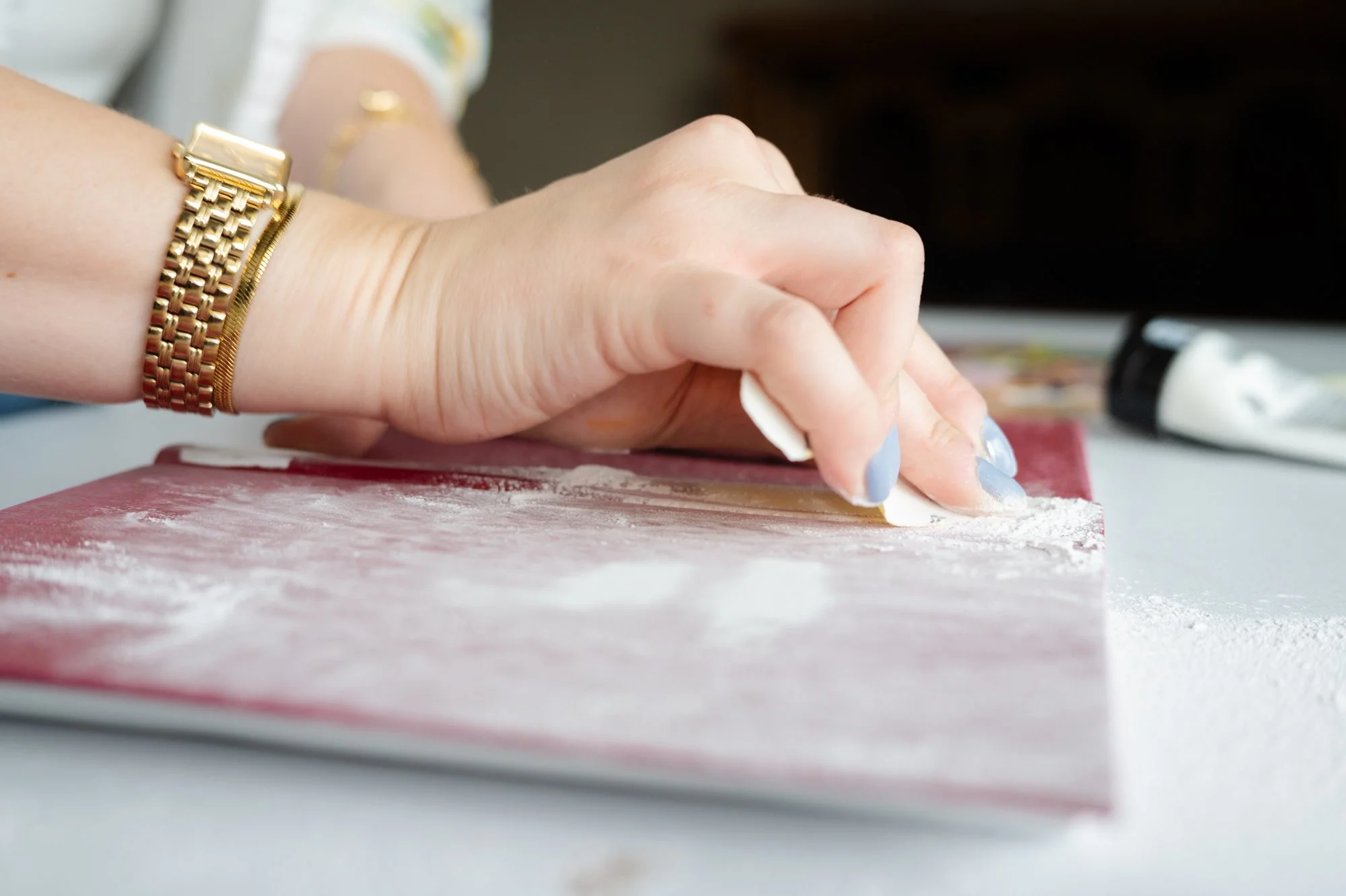 Hand som slipar en Bibel, hand håller ett sandpapper.
