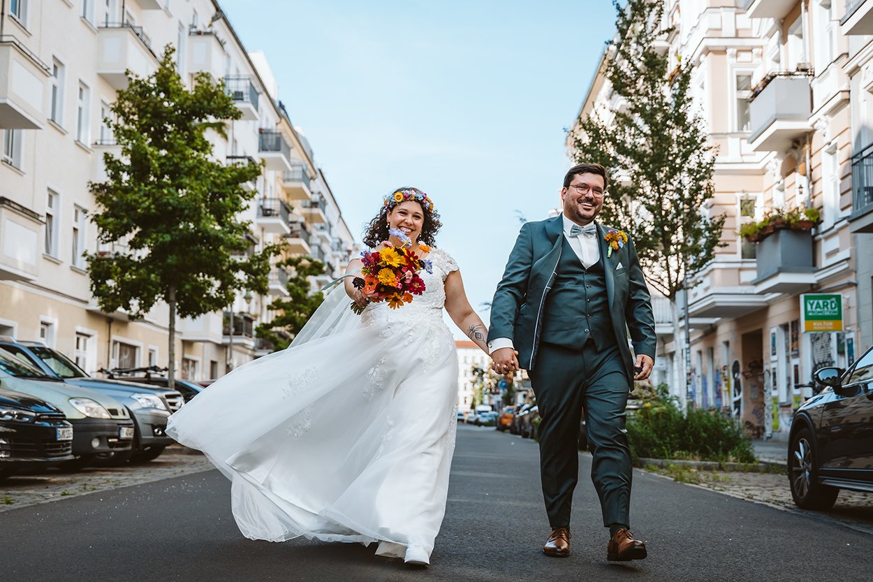Brautpaar Hand in Hand auf Straße entlang