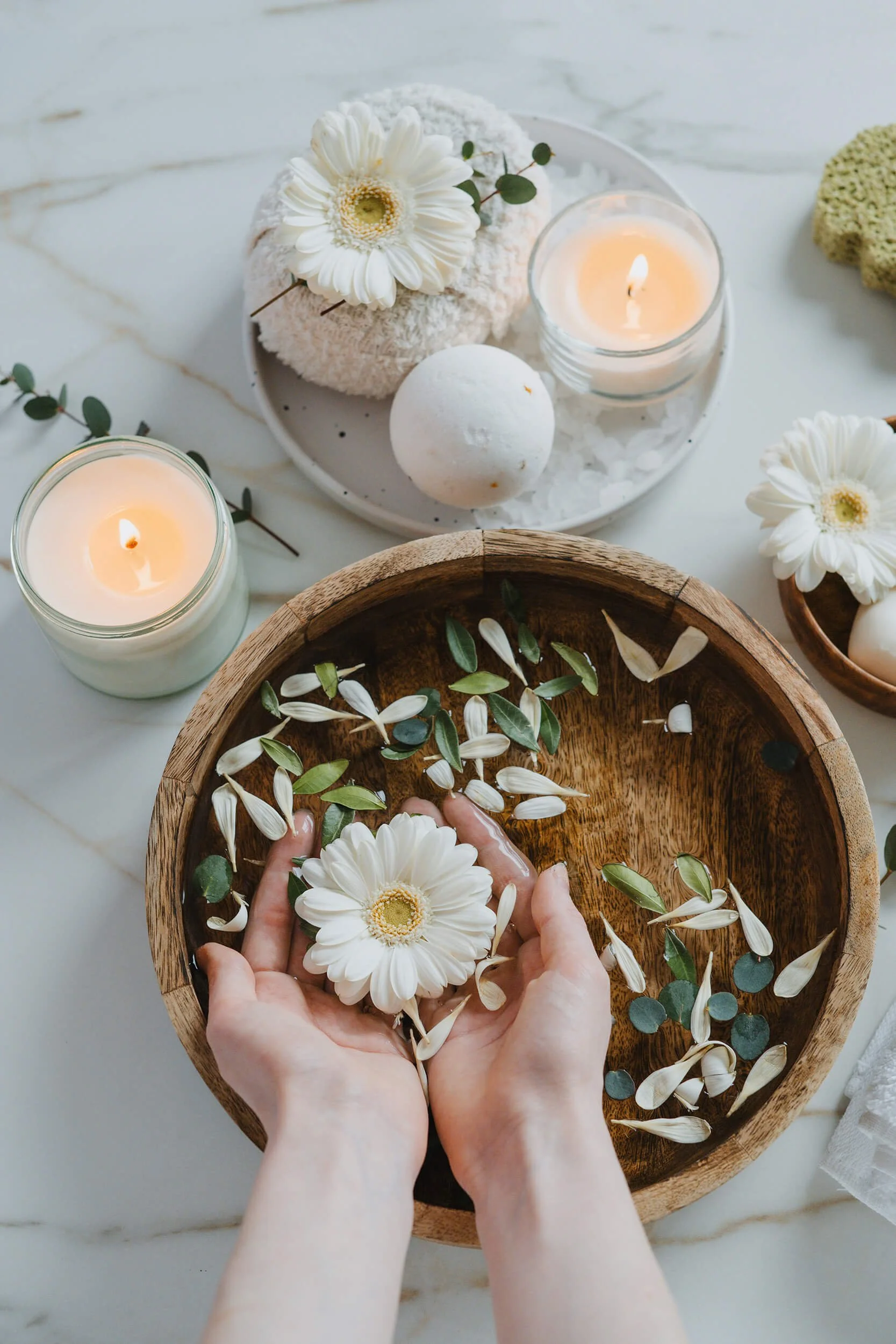 Hand holding flower over bowl of water at massage spa in Chesterfield, VA
