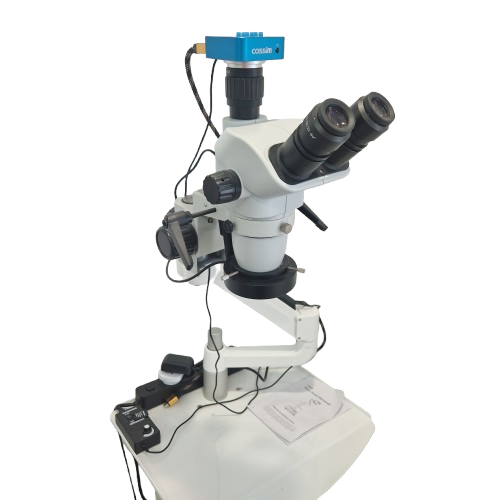Microscopio biologico con obiettivi doppi e monitor digitale, collegato a vari cavi e accessori.