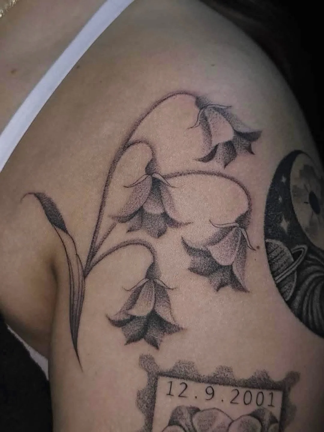 A delicate black and grey floral piece featuring soft bell shaped blossoms flowing naturally along the shoulder
.
.
Tattoo Artist: @ambrosia_tattoos 
.
.
Lagrange, GA