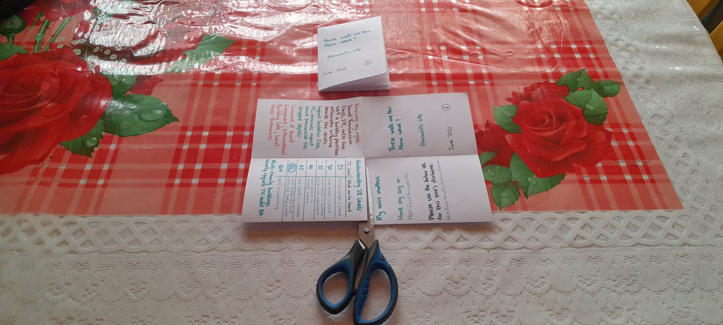 Scissors cutting along the centre crease of the folded paper to create the zine cut.